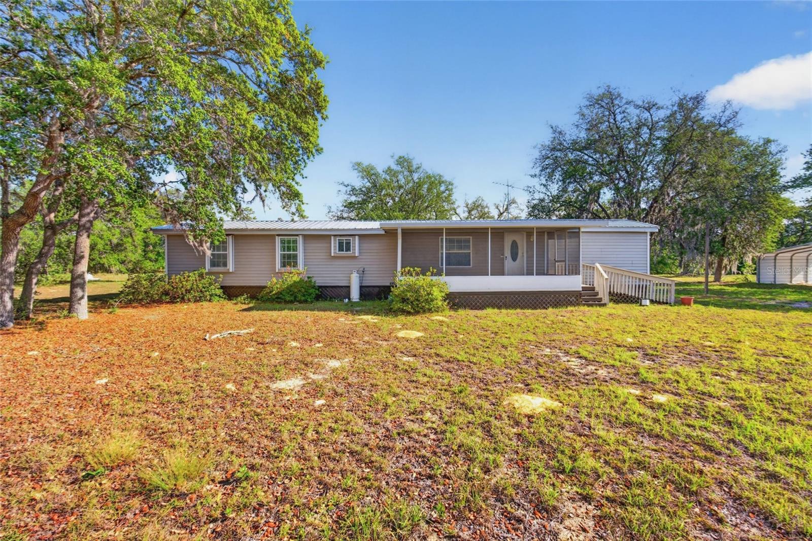 Nestled on almost five peaceful acres in Levy County near Archer, this well-maintained 2 bedroom, 2 bath mobile home offers the perfect blend of comfort, privacy, and country living. Bright and well-lit throughout, the home features a spacious and inviting interior with a newer AC system and a new metal roof for added value and peace of mind. The property is fenced and beautifully landscaped, creating a picturesque setting with plenty of room to enjoy the outdoors. A shed and carport add extra convenience and functionality for storage, equipment, or vehicles. Ideally located close to Archer Road for easy access to Gainesville, shopping, and amenities, yet tucked away on a quiet private road offering peace and seclusion. Enjoy the open space for gardening, animals, hobbies, or simply relaxing under the Florida sky. A wonderful opportunity for those seeking space, serenity, and affordability.