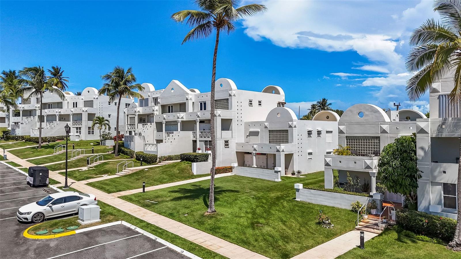 Welcome to your private sanctuary where Caribbean luxury meets resort living in one of Dorado's most coveted addresses. This completely renovated three-bedroom, two-and-a-half-bath end-unit condo represents the pinnacle of island sophistication, where every detail has been meticulously curated to deliver an uncompromising lifestyle of elegance and ease. Step inside this two-story masterpiece and immediately sense the difference. This isn't just another renovation—this is a complete transformation executed with no expense spared. From the moment you cross the threshold, premium finishes surround you: exquisite flooring that flows seamlessly throughout, custom cabinetry crafted to perfection, designer countertops that make a statement, top-of-the-line appliances that blend beauty with performance, and impact windows that frame your paradise views while providing peace of mind. Every surface, every fixture, every finish reflects uncompromising quality. The heart of this home is its spectacular open floor plan, designed for the way you want to live. Natural light pours through expansive windows, illuminating spaces that flow effortlessly from entertaining areas to intimate retreats. Your private patio becomes your personal oasis—imagine savoring the gentle Caribbean breeze while overlooking the pristine golf course, the perfect backdrop for morning meditation or evening cocktails. Start your day on the front terrace with freshly brewed coffee, planning your paradise agenda. Ascend to the primary suite where a generous balcony reveals breathtaking mountain vistas, your private perch for watching sunsets paint the peaks. The top guest bedroom offers an unexpected treasure: captivating ocean views that remind you daily why you chose island living. But the true luxury here extends far beyond your front door. Your home sits within the prestigious Embassy Suites Resort community, where world-class amenities create an everyday vacation lifestyle. You're mere footsteps from sugar-sand beaches where palm trees sway in the tropical breeze and waves crash rhythmically against ancient rocks. When you're not enjoying your private residence, explore three distinct on-site restaurants, perfect your swing at the golf course or driving range, compete on pickleball courts, bowl a few frames, try your luck at the casino, challenge friends to billiards, or experience the thrill of the indoor go-kart track. This is resort living without the resort fees—it's simply home. The practical luxuries matter too. A backup generator ensures uninterrupted comfort regardless of weather, while the water cistern provides invaluable peace of mind—essential infrastructure that savvy Caribbean residents appreciate. As a coveted first-floor end unit backing to the golf course, this property offers both convenience and prime positioning. Location completes this exceptional offering. Nestled within an exclusive private gated community, you'll enjoy security, serenity, and the soothing tranquility that defines authentic Caribbean living. Yet you're never isolated—the charming town of Dorado, with its rich cultural tapestry, acclaimed restaurants, and convenient shopping, sits just minutes away. This is more than a property; it's a lifestyle transformation. It's waking to ocean breezes and mountain views. It's walking to dinner or the beach on impulse. It's living where others vacation, in a home where quality meets convenience, luxury embraces livability.