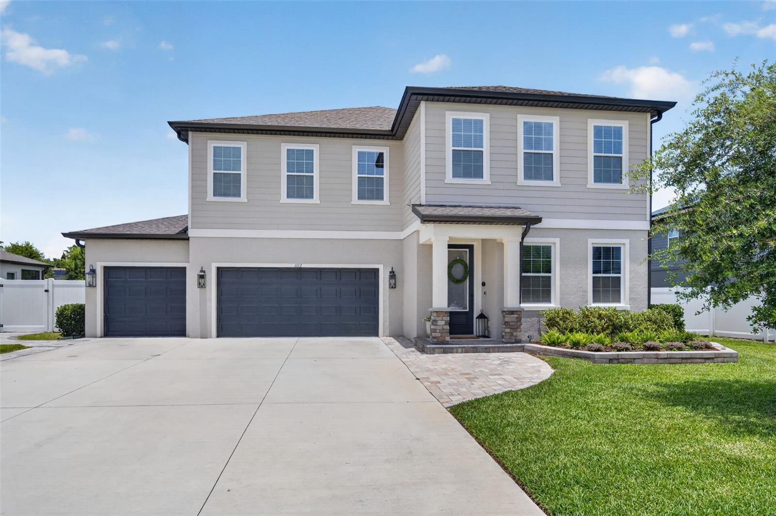 Welcome to 1112 Pearl Tree Road, where modern style meets everyday comfort in the sought-after Hampton Oaks community of Deltona. With 3,703 square feet of living space, this beautifully upgraded 4-bedroom, 3.5-bath home offers the perfect combination of functionality, luxury, and room to grow.

From the moment you walk through the front door, you'll appreciate the bright, open layout, soaring ceilings, and tasteful finishes that make this home feel both impressive and inviting. The kitchen is truly the centerpiece of the home, featuring a massive quartz island, 42-inch cabinetry with crown molding, stainless steel appliances, and a convenient dry bar that connects seamlessly to the formal dining room. Custom floating shelves with integrated lighting add character and style, making the dining space perfect for hosting family gatherings or dinner parties.

The main living area is flooded with natural light, creating a warm and welcoming atmosphere. A sleek electric fireplace serves as a beautiful focal point, adding both style and ambiance to the space.

The home also features a versatile office space anchored by a beautiful custom built-in bookshelf, offering the perfect setting for productivity, relaxation, or displaying your favorite collections.

Upstairs, the spacious primary suite feels like a private retreat. Thoughtful design details, custom accent walls, and an electric fireplace create a relaxing space to unwind at the end of the day. The ensuite bathroom features a large walk-in shower, dual vanities, generous counter space, and a custom-designed closet with built-in storage to keep everything organized.

The additional bedrooms are generously sized, including one with its own private ensuite bathroom, making it ideal for guests or multigenerational living.

Even the everyday spaces have been thoughtfully upgraded. The laundry room offers plenty of storage, open shelving, and a colorful backsplash that adds a little personality to the space. The three-car garage has been transformed into a versatile area with epoxy flooring, custom lighting, mirrors, and a mini-split AC system, making it perfect for a home gym, workshop, or hobby space.

Outside, you'll find a screened patio that opens to an extended paver lanai and fully fenced backyard, creating a private setting for entertaining, grilling, or simply enjoying Florida's beautiful weather.

Conveniently located near I-4, this home provides easy access to Orlando, area beaches, shopping, dining, and everything Central Florida has and more. If you've been looking for a home that checks all the boxes while offering thoughtful upgrades and plenty of space, 1112 Pearl Tree Road deserves a spot at the top of your list.

Upgrades include- Backyard Pavers, Stone, Driveway and Walkway, Fence, Screened Lanai, Garage Epoxy,Mini split, Rock Perimeter, Custom Shelving, Front Door with Privacy Window, Cabinet Crown Molding, Solar Power Shades, Trim Molding. Please see attached updates and improvements list.