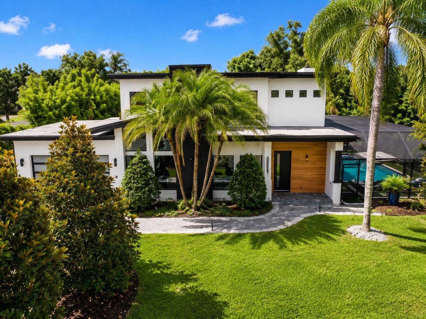 A PRIVATE RESORT-STYLE SANCTUARY IN THE HEART OF WINTER PARK

5 Bedrooms | 4 Bathrooms | 3,400+ SF | Saltwater Pool & Spa | Smart Home | Minutes to Park Avenue

Welcome to a rare offering where luxury, tranquility, and architectural sophistication converge. Nestled within one of Winter Park's most desirable neighborhoods and just minutes from the boutiques, fine dining, and cultural attractions of Park Avenue, this custom Mid-Century Modern residence delivers an extraordinary lifestyle defined by elegance, wellness, and privacy.

Thoughtfully designed with a Zen-inspired aesthetic, the home seamlessly blends clean architectural lines with warm natural elements to create a living experience that feels refined and restorative. From the moment you arrive, an atmosphere of calm surrounds you, offering a peaceful escape while remaining moments from everything Winter Park has.

Inside, soaring 10-foot ceilings, expansive walls of glass, and wide-plank engineered hardwood flooring create bright, open living spaces filled with natural light. A stunning semi-floating steel staircase with solid whiteoak treads serves as a dramatic architectural focal point, while designer Restoration Hardware lighting adds warmth and sophistication throughout.

The main living area was designed for entertaining and everyday luxury. A sleek Dimplex fireplace anchors the great room, complemented by a custom wine bar. At the heart of the home, the chef's kitchen showcases a waterfall island, premium quartz countertops, striking marble backsplash, double-stacked cabinetry, and a custom pantry. High-end Samsung smart appliances, including a Family Hub refrigerator, WiFi-enabled convection wall oven, Flex Duo cooking system, and 36-inch Bluetooth cooktop, complete this exceptional culinary space.

A first-floor guest suite and full bath provide flexibility for visitors, a private office, fitness studio, or wellness retreat. The finished two-car garage features epoxy flooring and a modern glass garage door.

Upstairs, the primary suite serves as a private sanctuary. The spa-inspired bath features a freestanding soaking tub, expansive dual-entry shower wrapped in marble, semi-frameless glass enclosure, dual vanities, and a custom walk-in closet.

Beyond the walls of the home lies your own private paradise. Professionally designed by Exotic Landscape Company, the resort-caliber outdoor living experience evokes the serenity of a luxury Balinese retreat. The newly constructed saltwater pool and spa showcase glass tile finishes, mini-pebble surfaces, travertine coping, LED lighting, therapy jets, a cascading waterfall, and smartphone-controlled OmniLogic automation. A custom outdoor stone shower, yoga platform, lush tropical landscaping, and curated hardscapes create an environment dedicated to relaxation and wellness.

Additional features include Eufy smart lock technology, Arlo video doorbell, Google Nest thermostat, WiFi-enabled irrigation, smart garage controls, Quality Edge Vesta steel plank siding, and an expanded driveway.

Located nearby highly regarded Winter Park schools and less than ten minutes from Park Avenue, this exceptional residence offers a rare opportunity to own a home that feels more like a private luxury resort.

More than a home, this is a sanctuary. A place to unwind, recharge, and experience the very best of Winter Park living.