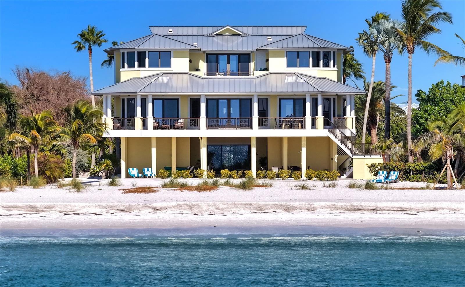 100' of direct beach and gulf frontage..... Welcome to Paradise! Experience the ultimate in Longboat Key and Gulf-front luxury with this spectacular nearly 6,000 sq. ft. beachfront estate on Longboat Key. Perfectly positioned on a pristine stretch of white-sand shoreline, this gorgeous beach home offers unobstructed, panoramic views of the Gulf of Mexico from nearly every room in the home. Also featuring over 3,000 sq. ft of under-roof outdoor relaxation and entertainment space. Designed for family gatherings and beach front fun, this is the perfect beach home for tranquil coastal living. This beach home features 6 bedrooms, 6.5 bathrooms, a den and a family room, as well as a stunning 24' x 24' rooftop sun deck. Built in 2002, this waterfront beauty offers many unique details like the Mahogany front door, elevator to all 3 levels, all new exterior paint and interior paint, and best of all three expansive levels of outdoor living space, each capturing the beauty of daily sunsets and unobstructed Gulf and beach views. At the heart of your beachfront oasis is a newly refurbished resort-style pool and new paver patio, framed by swaying palms and endless water views. Just steps beyond the pool is access to your 100' of private beach frontage leading directly to the soft sand and crystal-blue Gulf waters. The main level Owner's suite is large, with direct and unobstructed Gulf and beach views.  The kitchen is spacious and open, with top-of-the-line appliances and direct Gulf and beach views to enjoy while you cook. The guest bedroom suites are all spacious, with ensuite bathrooms and great Gulf and beach views from every bedroom. Whether you’re seeking a serene retreat or an entertainer's dream, this exceptional Longboat Key residence delivers unparalleled beauty, privacy, and a front-row seat to Florida’s most breathtaking coastline. Hurry up and get here, the views are spectacular!