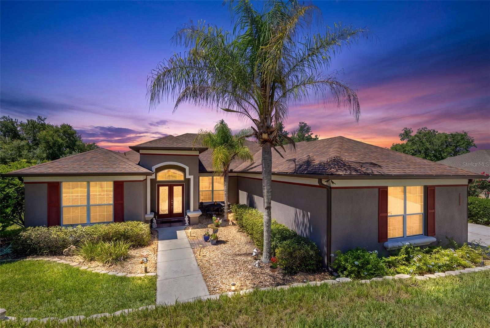On nearly one acre in an established neighborhood of custom homes amid the rolling hills of Montverde, this beautifully maintained four-bedroom, three-bath home offers the ideal balance of privacy, comfort and convenience. A light-filled interior hallway flows from the formal living room (can also be an office or a den) and dining room to the spacious family room and stunning remodeled kitchen featuring white shaker cabinetry, quartz countertops, a built-in double wall oven, Samsung Smart French door refrigerator with beverage center, built-in beverage refrigerator and thoughtful custom storage solutions. Double doors open to the private primary retreat with a walk-in closet and en-suite bath, while the split-bedroom design places three additional bedrooms and two full baths in a separate wing, providing an ideal layout for family members or guests. Go outside to enjoy peaceful elevated views from the south-facing screened pool, surrounded by mature trees, lush landscaping, and plenty of space to relax, entertain or create your dream backyard gathering area with the ideal spot for a future fire pit. Additional highlights include a three-car garage with a workbench and utility sink, an indoor laundry room with smart washer/dryer combination and laundry sink, an outdoor Viking range, a herb garden, and a separate powered workshop/studio ideal for hobbies, crafting, projects or storage. Complete with a riding lawn mower and lawn equipment, this exceptional property offers a move-in-ready lifestyle. Enjoy the tranquility of country living just minutes from Montverde Academy, the Turnpike, SR 429, lake and boating access, shopping, dining and convenient access to Orlando.