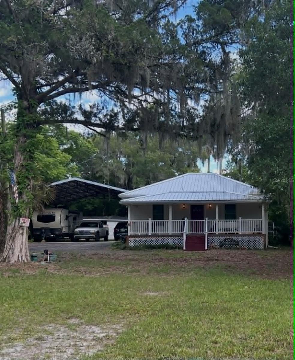 2/2 remodeled (2023/2024) home on 1.27acres in a great location on the west side of Deland with no HOA.  Open layout with kitchen, dining, and living room, (also large bath with hookups for laundry) in the front of the home.  Some upgrades include new metal roof, new front porch, newly screened back porch, new LVP flooring, windows, walls were taken to the studs and replaced, electrical and plumbing updated.  Two kitchen areas could allow the second bedroom to be turned into an efficiency apartment with it’s own entrance and laundry.  Detached 27’X20’ garage has been divided to provide a dehumidified and secure area for additional storage or could be turned into an ADU if desired.  There is a new 32’X30’ covered/cemented parking area with room for an RV. Vinyl siding (low maintenance) and very well insulated with low heating/AC costs.  Other utilities are low as well - on septic but has city water, so bill is only ~$25/month; T-Mobile internet is $50/month and works well.  Decent rentals are hard to come by in the area and are in great demand with proximity to Stetson University.  The lot is large and very private with a gated entrance and the house is set well back off the road.  There are sour orange and loquat trees, it’s mostly fenced, and easy to care for.  Two popular restaurants within walking distance and less than a mile to the new SunRail station, also about a mile to Winn Dixie.  Close to downtown without the traffic, easy access to Orlando and Sanford.  Current owner is building nearby and would give special consideration/discount if able to stay in home temporarily after closing, until new home is completed.