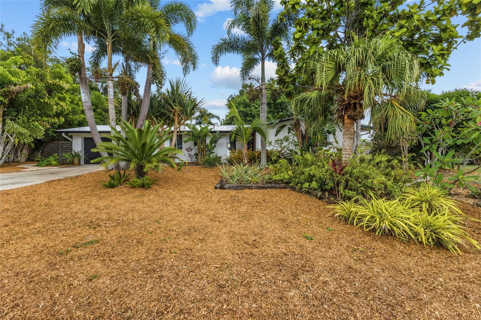 This delightful 2-bedroom, 2-bathroom home, plus space to create an office/guest house offers 1,669 square feet of inviting living space. It’s the perfect place to enjoy the laid-back Florida lifestyle. As you step inside, you’re greeted by charming terrazzo floors that bring a touch of retro style to the home. The spacious eat-in kitchen is ideal for entertaining or enjoying a quiet dinner at home. Hurricane impact windows throughout and new roof provide added storm protection, energy efficiency and peace of mind. Retreat to the primary bedroom suite that offers a comfortable and private retreat with generous closet space and an en-suite bath designed with clean finishes. Retreat outside to your private backyard oasis.  The fully fenced back yard features lush gardens, creating a tranquil and picturesque setting ideal for relaxing or entertaining.  The stand-alone building has been built with hurricane standards and has so many possibilities to enhance your life.  Come make it your own -