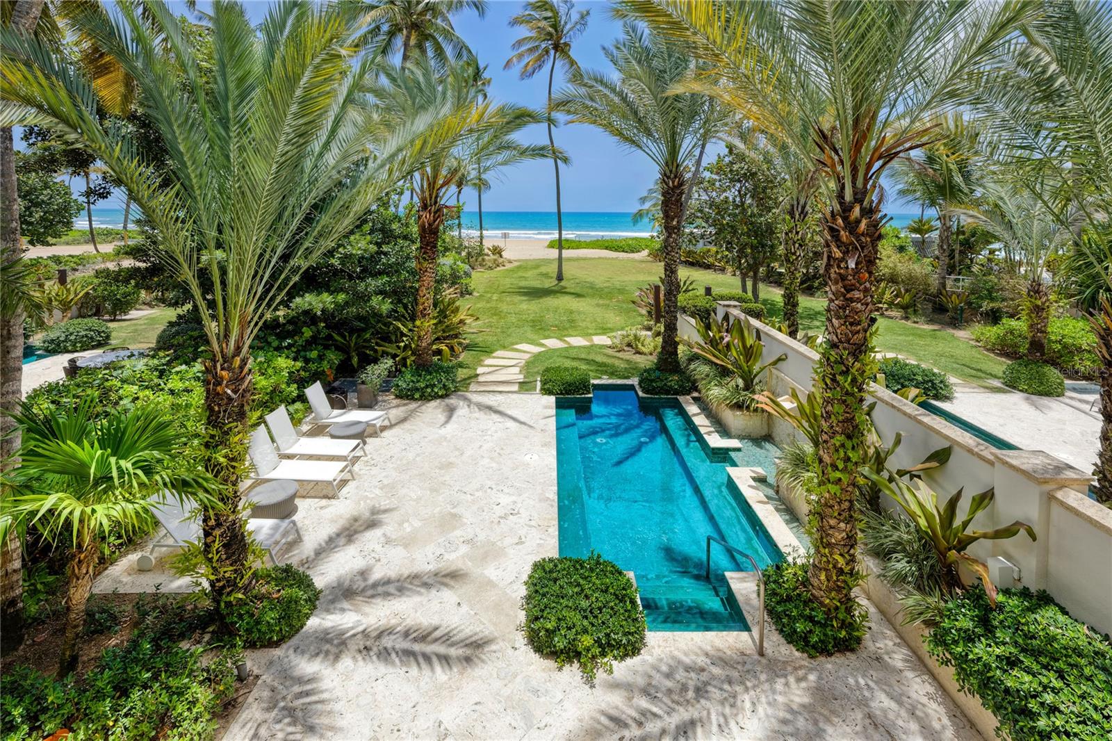 Auction Property. ***SOLD*** An exceptional beachfront residence within Las Olas at the prestigious Bahia Beach Resort & Golf Club, this spectacular townhome offers sophisticated coastal living with direct ocean views. One of only four exclusive residences steps from the Beach Club, this two-story sanctuary spans 2,930 square feet of refined living space. Four bedrooms with walk-in closets and four full baths provide abundant space for family and guests, while expansive terraces and a private plunge pool create seamless indoor-outdoor living. Cathedral ceilings and French doors maximize natural light and ocean breezes throughout. As part of the esteemed Bahia Beach community, residents enjoy world-class amenities including championship golf, tennis, pickleball, and exclusive beach club access. This move-in-ready retreat represents the pinnacle of Puerto Rican resort living.