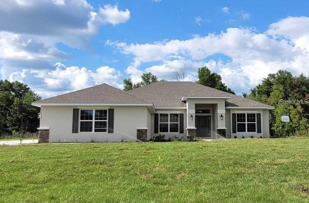 Under Construction. Brand new CONCRETE BLOCK home under construction. Estimated completion is approx Dec/Jan  pending any setbacks beyond the builders control. Just a short drive to the World Equestrian Center or Rainbow River!  Over 1 acre lot!  Home will have a side load 3 car garage and stone pkg on home. Great open floor plan for entertaining.  Tray ceiling in the owners suite with access to covered lanai. Living room has double doors to allow for many uses of this space. (Den, study or 5th bedroom) Great floor plan for entertaining. Bath 2 has access to lanai. Many features include upgraded cabinets, granite counter tops, stainless appliance pkg (range microwave and dishwasher included), tile shower with separate soaking tub in owners bath, mini blind inserts in rear exterior doors, TILE ALL AREAS EXCEPT BEDROOMS (bedrooms and closets will have carpet), irrigation system and much more! TAEXX pest control system built in home. Builder warranty! Builder helps with closing costs if Buyer pays cash or closes with a Seller approved lender. Prices /Promotions are subject to change without notice. Pictures are of a similar home for illustrative purposes only. Colors and features will vary!