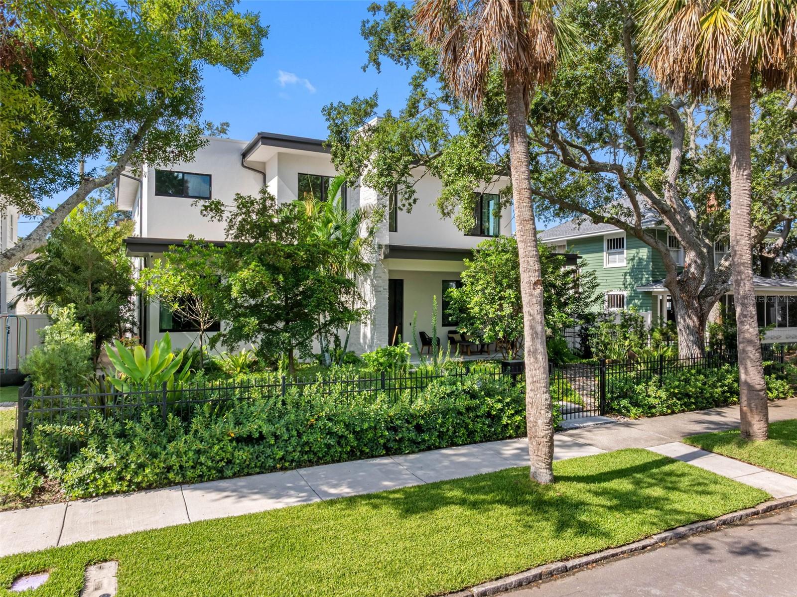 California modern nestled in the heart of all the charm and tradition of Historic Old NE.This
2023 solid block home with steel trusses/framing enveloped in Icynene insulation is built to
stand strong and still be eco friendly.Solar panels generate enough electricity to run the house
and 2 electric vehicles with the minimum Duke charge. The verdant, xeriscaped yard, leads up a
modern path to the grand, pivot door. Inside, polished concrete floors seamlessly give a clean,
modern aesthetic with a palette of brown woods, black, and brass. Nine foot sliding doors
surround the courtyard, opening the entire first floor to a screened, private sanctuary
surrounded by lush greenery.The gathering room with 11’ ceilings, and a linear fireplace that
gives year round ambiance, is just far enough away from the kitchen to give it a luxurious feel
but still part of the action.The kitchen overlooks the courtyard with floor to ceiling custom oak
cabinetry.Everything is expertly designed to give gracious amounts of counter space and
storage.Monogram appliances include a large induction cooktop, dishwasher, and double oven
with Advantium.The restaurant sized fridge and freezer tucked in the large pantry not only give
you the most food storage possible but also allow for ease of organizing and placing groceries.
Rich black granite with brass veins hugs a massive waterfall island and deep sink.The wet bar,
with reverse osmosis system, beverage cooler and reeded glass cabinetry make this the
perfect conversation area.The pool bath opens to the courtyard truly making this inside/outside
living year round.The courtyard and pool area continue maintenance free living with soft turf, an
eight person jacuzzi and the ability to heat the pool and jacuzzi with solar. Completing the
ground floor is a flex space currently used as a media room with surround sound system that
could also be an office, gym or playroom. The entire ground floor has a Sonos sound
system. The floating staircase is a work of art leading to the second floor, with solid oak treads,
glass railings and steel beams. Immediately at the top, is a large laundry room with GE profile
graphite appliances, a deep sink, long quartz counter and upper and lower cabinets. The entire
second floor is clad in a rich hued, wide oak plank. The private, primary suite has an
exceptionally large walk-in closet, and spacious light-filled bath with floating oak
cabinetry,Italian terrazzo walls, and seamless porcelain flooring that give the juxtaposition of
old and new. Two additional bedrooms, with pool or treetop views, sized for king beds, have
custom closet systems and a bathroom that pays homage to the sidewalks of Old NE with hex
tile, Oak cabinetry and brass and black accoutrements. The guest house has a bedroom, full
bath, kitchenette, living room, and is one of best spaces on the property. A West facing balcony
is the perfect sunset aperitivo spot. A three car garage with alley access, a fenced yard and security
cameras are a few of the extras. Walk three blocks to the water and enjoy the third largest
waterfront park system in North America with sand volleyball, pool, playgrounds, the beach,
live music, art and food festivals and amazing sunrises. A mile stroll will have you in the buzzing
downtown scene. A bike ride or walk is great way to get to all that downtown offers-museums,
shopping, restaurants with Michelin nods, the Saturday Market,Grand Prix and the magnificent Pier.