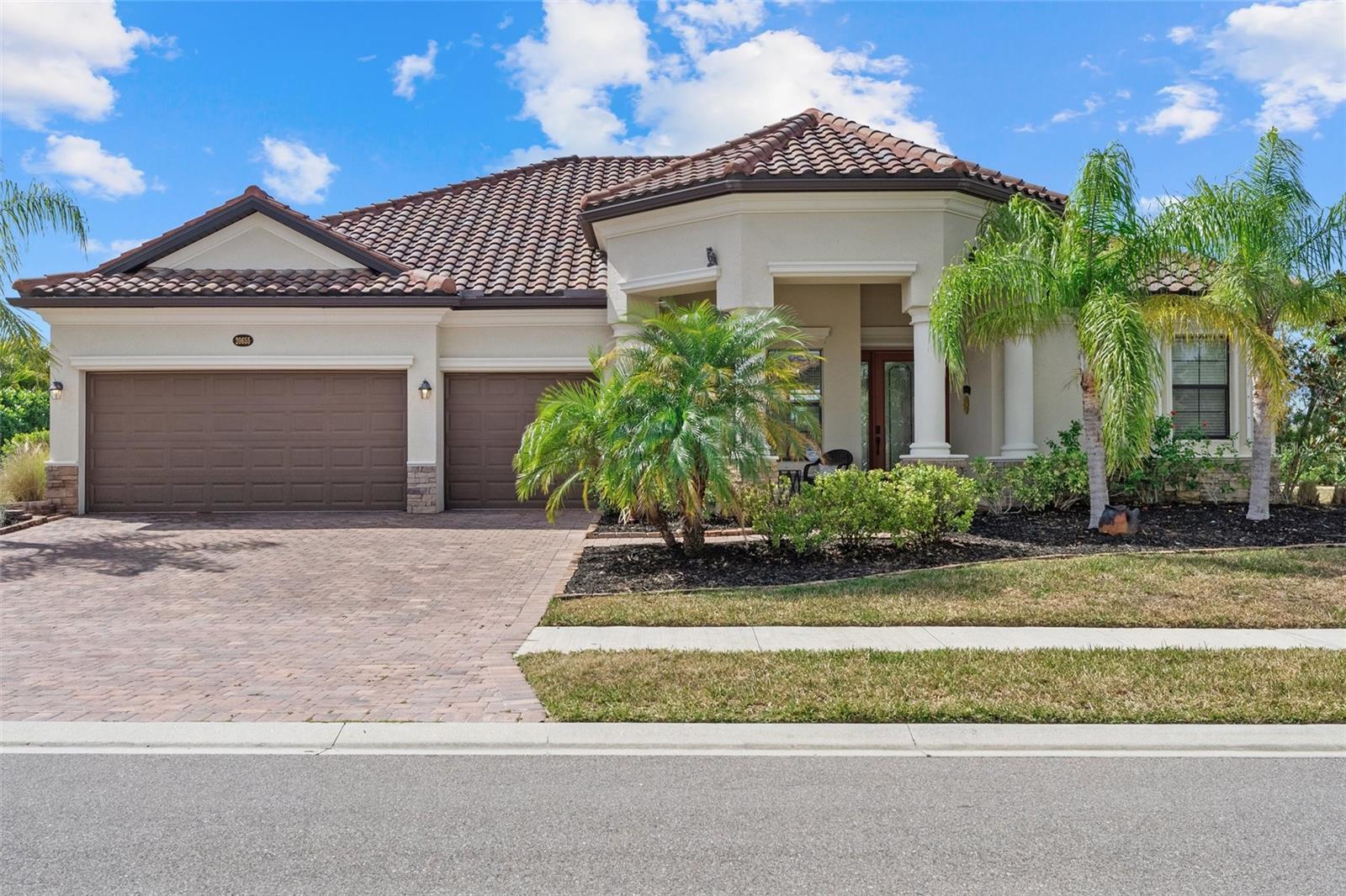 Wake up each day to shimmering lake views, warm Gulf breezes, and the effortless elegance of resort-style living in Gran Paradiso, one of the most sought-after, golf-cart-friendly enclaves in Wellen Park. Perfectly positioned on an oversized waterfront homesite, this four-bedroom, three-bath residence with a three-car garage captures breathtaking sunsets and the serene rhythm of Florida living.
From the moment you arrive, the home welcomes you with a sense of space and refinement—soaring ceilings, extended doorways, crown molding, and elegant tile flooring create a light-filled, airy atmosphere designed for both everyday comfort and elevated entertaining. The open great room flows seamlessly into a chef’s kitchen where granite countertops, custom cabinetry, stainless steel appliances, tile backsplash, under-cabinet lighting, and generous pantry space make hosting effortless. Morning coffee becomes a ritual in the sunlit breakfast nook, where aquarium glass frames peaceful water views.
Sliding glass doors disappear to reveal over 1,000 square feet of indoor-outdoor living, where a screened paver lanai, resort-style pool and spa, and expansive lake backdrop create a private retreat ideal for sunset dinners, weekend lounging, and unforgettable gatherings. The primary suite is its own sanctuary, offering tranquil lake views, direct lanai access, a walk-in closet, and a spa-inspired bath with dual vanities, soaking tub, and walk-in shower. A thoughtful split floor plan provides privacy for guests, including a bedroom and full bath that doubles as a pool bath, while a formal dining room sets the stage for memorable celebrations.
Beyond the home, life in Gran Paradiso feels like a permanent vacation. Residents enjoy a guard-gated entrance, a stunning Tuscan-inspired clubhouse, resort pool and spa, state-of-the-art fitness center, sauna, tennis and pickleball courts, walking trails, and a vibrant calendar of social events that foster a true sense of community. HOA services include cable, high-speed internet, lawn care, and full access to amenities—allowing you to spend more time living and less time maintaining.
Additional features include hurricane protection for windows and sliders, UV-enhanced HVAC air purification, mature landscaping for privacy, overhead garage storage, and peace of mind in an X flood zone with no flood insurance required. Just minutes from beaches, downtown Venice, dining, shopping, and the Atlanta Braves’ Spring Training stadium, this home offers not just a place to live—but a lifestyle to love.