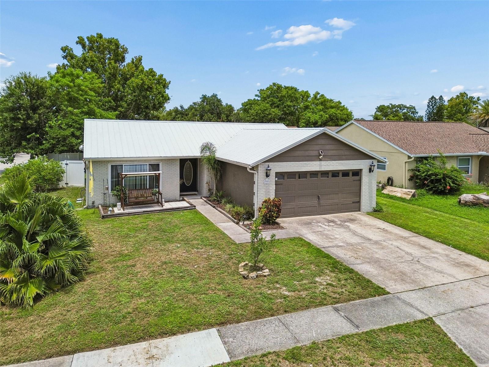 Welcome to this beautifully updated 2 bedroom, 2 bathroom home in the highly sought-after Seven Springs community of New Port Richey, Florida. Combining modern updates, a functional layout, and an unbeatable location, this move in ready home offers the perfect blend of comfort, style, and everyday convenience. Inside, you'll find a bright, open floor plan designed for effortless living and entertaining. Natural light fills the spacious great room, while the adjoining dining area flows seamlessly into the updated kitchen, creating an inviting space for gathering with family and friends. Durable tile flooring extends throughout the home, providing low maintenance living with a clean, cohesive look.  A spacious rear family room offers exceptional flexibility and can easily serve as a second living area, home office, media room, hobby space, or even be converted into a potential third bedroom. Sliding glass doors open to a covered screened porch, creating the perfect indoor-outdoor living experience overlooking the private, fully fenced backyard.
The generously sized primary suite comfortably accommodates a king-size bedroom set and features a large walk-in closet with custom built-in organizers. The private ensuite bathroom includes dual vanities, abundant linen storage, and an oversized roll-in tiled walk-in shower designed for both comfort and accessibility. The guest bedroom is equally spacious and is conveniently located adjacent to the updated guest bathroom.
Additional features include a durable metal roof, updated mechanical systems, an inside laundry room, and a spacious 2 car garage, providing peace of mind and long term value.  Step outside to enjoy the fully fenced backyard complete with a charming trellis, covered patio, and plenty of space for pets, gardening, outdoor dining, or weekend entertaining.
Ideally located in the desirable Seven Springs neighborhood, this home is just minutes from Seven Springs Elementary School, Trinity, Starkey Ranch, shopping centers, restaurants, golf courses, medical facilities, parks, and the Gulf beaches. With convenient access to major roadways, commuting throughout Pasco County and the Tampa Bay area is simple.
Whether you're a first-time home buyer, retiree, downsizing, or searching for a well-maintained Florida home with modern updates and flexible living space, this exceptional Seven Springs property is ready to welcome you home. Schedule your private showing today and discover everything this beautiful New Port Richey home has to offer.(ROOF-2016)(A/C-2015)(W/H-2019)