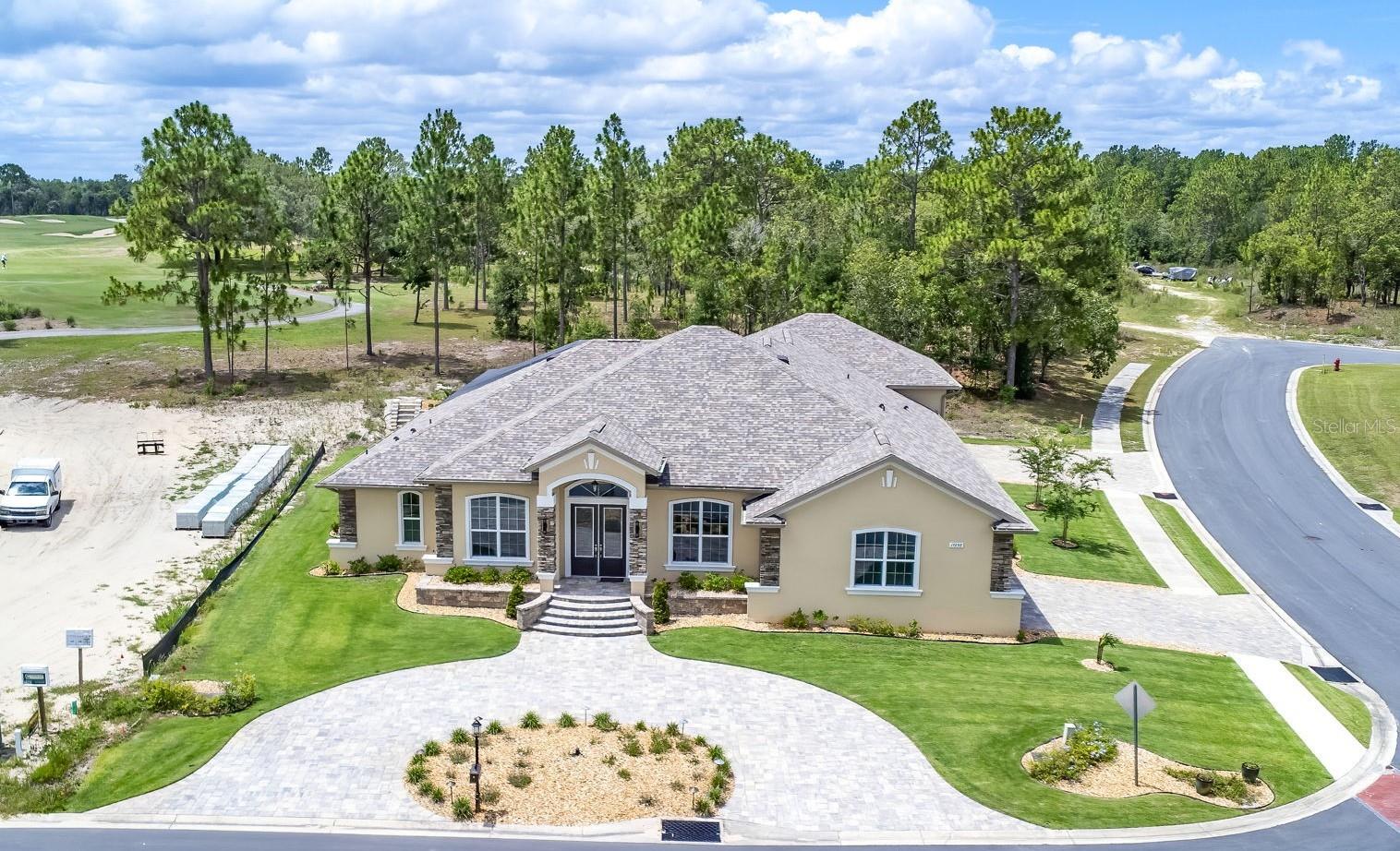 5 Bedroom Custom Home | Boat & RV Garage | Outdoor Kitchen | Top-Rated Golf Course Views | Gated Community Welcome to this exceptional CUSTOM-BUILT Curington home situated on a premium corner lot in the gated golf course community of Juliette Falls. A circular paver driveway and grand entrance create an impressive first impression. Car and recreation enthusiasts will appreciate the DOUBLE GARAGE SETUP, including a front garage for two vehicles plus a golf cart and a massive 36-foot-deep rear garage with 12-foot doors, ideal for boats, RVs, or additional storage. Both garages and lanai feature durable epoxy flooring. The OUTDOOR LIVING AREA is designed for entertaining and relaxation, featuring a dramatic two-story screened enclosure, a relaxing spool with illuminated waterfall, and an entertaining deck overlooking holes 1–4 of the golf course. The covered lanai includes seating and dining areas, a six-person Master Spa HOT TUB, and a fully equipped OUTDOOR KITCHEN with built-in griddle, searing stations, sink, prep space, granite counters, and bar seating for six. There is also ample space to add a full-size pool if desired. INSIDE, soaring ceilings, 8-foot doors, crown molding, and a modern open split-floor plan create a spacious and elegant atmosphere. The home offers five bedrooms and three full bathrooms. The FORMAL DINING ROOM showcases a coffered ceiling with accent lighting, chandelier, built-in hutch, recessed niche, and quartz serving bar. The GOURMET KITCHEN features an oversized and elevated island with Alaskan granite, seating for four, abundant cabinetry, whquartz countertops, farmhouse sink, beverage refrigerator, walkin pantry, and premium stainless appliances including a wall oven, microwave, induction cooktop, decorative hood, and LG French-door refrigerator. A built-in desk and corner WET BAR with lanai access make entertaining effortless. The expansive GREAT ROOM centers around a modern linear fireplace and 82-inch TV feature wall with built-in bench seating, floating shelves, and coffered ceiling. Triple pocket sliders open seamlessly to the lanai for true indoor-outdoor living. The luxurious PRIMARY SUITE offers a private sitting area, coffered ceiling, dual custom walk-in closets, and a spa-inspired bath with dual vanities, floor-to-ceiling tiled shower, dual shower heads, dual built-in niches, and transom window. Three ADDITIONAL BEDROOMS are located in a separate wing, including a Jack-and-Jill layout and guest bath. A fifth bedroom or den at the front of the home provides flexibility for guests or office space. Numerous FEATURES include a well-equipped laundry room, two tankless water heaters, dual HVAC systems with three zones, whole-house water filtration, public utilities, and a separate irrigation well with Wi-Fi-enabled sprinkler system. Luxury vinyl plank flooring runs throughout the home, with tile in wet areas. Located near Rainbow Springs State Park and convenient to shopping, dining, healthcare, and the World Equestrian Center, this home offers upscale living within two hours of both Tampa and Orlando and about 30 minutes from Florida’s Gulf Coast.