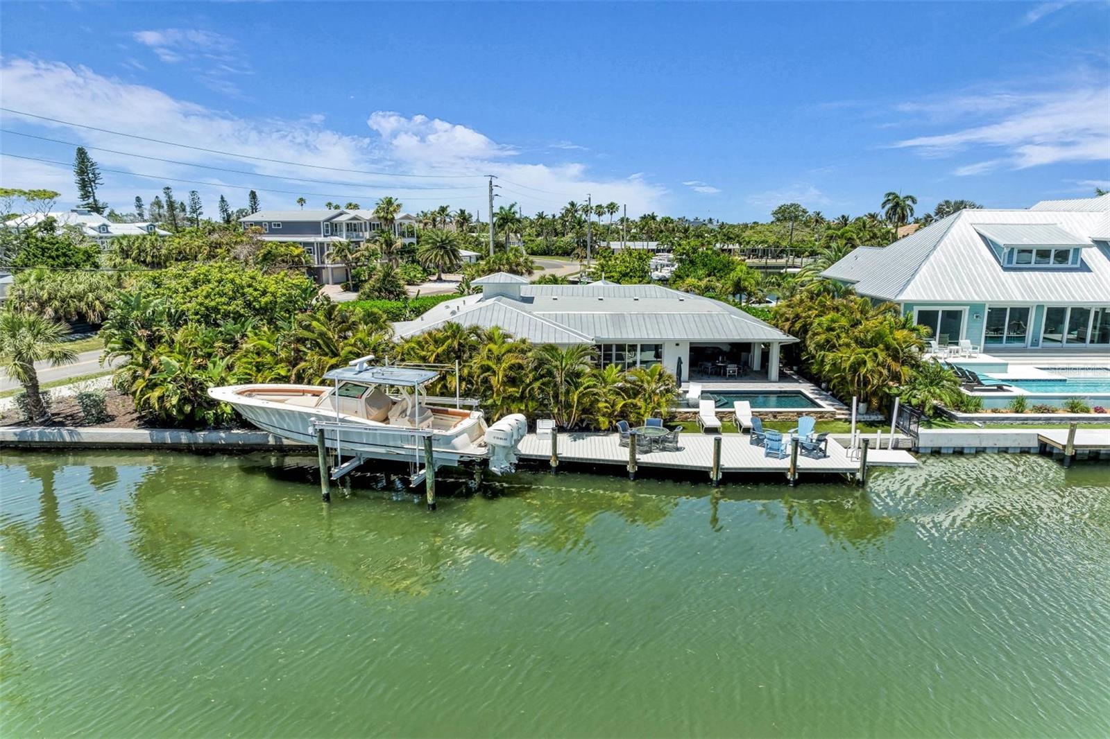 Welcome to 501 68th Street, located in the heart of Holmes Beach on beautiful Anna Maria Island. This exceptional waterfront home on the Grand Canal offers the ultimate island lifestyle—boating, sunshine, and world-class beaches just moments away.

This 4-bedroom, 3-bath coastal retreat features deep water access to Tampa Bay and the Gulf of Mexico and is offered furnished with a few exceptions. Southern exposure and lush landscaping create a private tropical setting with a mango tree and fenced backyard.

Designed for resort-style living, enjoy a heated pool, oversized spa, and 12x60 dock with 20,000 lb lift. Extensive 2021 upgrades include a new roof, impact windows and sliders, and updated dock and pilings.

Inside, white oak hardwood-look plank tile flows throughout. Two walls of impact sliders open to the water, while the family room offers a custom bar and vaulted tongue-and-groove ceilings. The chef’s kitchen is sure to please with quartz countertops, custom built-ins with appliance garages, a large island, and high-end appliances including a Fisher & Paykel stove and Bosch refrigerator.

The layout includes two guest bedrooms, a hidden laundry room, and a private primary suite with walk-in closet, water closet, and sliders to a secluded turf area by the pool. A flexible den serves as a fourth bedroom or guest space.

Enjoy the covered lanai overlooking the Grand Canal, pre-plumbed and wired for a future outdoor kitchen—perfect for entertaining.

Additional highlights include a 2025-installed 26KW whole-house generator with a 500-gallon propane tank, oversized garage, carport, and ample parking.

A rare opportunity to own a deep canal waterfront home in one of Anna Maria Island’s most desirable boating locations.** Property information received from third-party sources is considered reliable but is not guaranteed.  All information should be independently verified by buyers and buyer's agent.