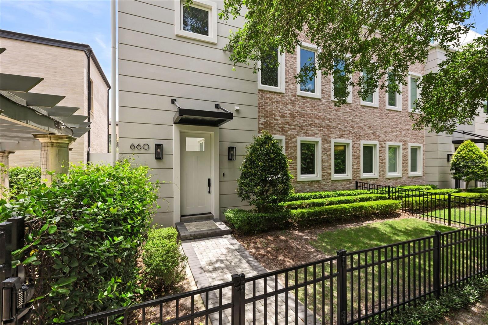 Hidden Gem! Designed and built by the acclaimed Phil Kean Design Group, this exceptional luxury townhome offers modern living in one of Downtown Winter Park’s most desirable locations. Situated in the heart of Hannibal Square and just three blocks from Park Avenue, this residence places premier dining, shopping, galleries, museums, Central Park and year-round community events within easy walking distance. Thoughtfully designed with both style and functionality in mind, the home showcases high-end finishes throughout including rich Brazilian walnut flooring, oversized 24 x 48 ceramic tile, coffered ceilings, quartz countertops, custom cabinetry and premium stainless-steel appliances. The chef’s kitchen is anchored by an eight-burner Wolf gas range and a Sub-Zero refrigerator, paired with a hidden pantry discreetly concealed behind custom cabinetry. A striking metal staircase serves as a central architectural feature, adding a contemporary design element that complements the home’s clean lines and sophisticated aesthetic. The open-concept floor plan is filled with natural light, enhanced by expansive windows throughout that frame peaceful green views and mature tree-lined surroundings. The main living areas extend seamlessly to the outdoors, where a first-floor entertaining wet bar with a wine refrigerator opens directly to the private courtyard, creating an effortless indoor-outdoor flow ideal for hosting. The courtyard features a fire pit surrounded by greenery, while the balcony off the main living area includes a summer kitchen. A fenced yard offers privacy and space for pets to enjoy. Designed for today’s lifestyle, the home includes a PRIVATE ELEVATOR servicing all three floors, dual HVAC systems, two tankless water heaters hardwired security cameras and a spacious three-car garage with an electric vehicle charging station and generous storage space. RARELY AVAILABLE in Downtown Winter Park, the oversized THREE CAR GARAGE offers exceptional functionality and flexibility. The private driveway provides additional parking while abundant guest parking nearby makes entertaining easy, an uncommon convenience in a downtown setting. The primary suite occupies the third floor, offering a private retreat with separation from the main living areas. It features a very large owner’s closet filled with natural light and a dedicated vanity area, creating a functional yet refined dressing space. Two additional bedrooms and a dedicated office or den provide flexibility for working from home, accommodating guests or creating additional living space. Each bathroom has been thoughtfully appointed with quality finishes and timeless design. Tucked within a quiet enclave , this residence offers a unique balance of privacy and walkability. The property is adjacent to the recently completed $6.1 million residence of internationally respected architect Kamal Rizk further underscoring the caliber of the surrounding neighborhood. Homes of this quality and location rarely come to market, presenting a truly limited opportunity to own in one of Winter Park’s most sought-after addresses. Combining the architectural vision and craftsmanship of Phil Kean Design Group with luxury finishes, modern conveniences and an exceptional location, this residence offers sophisticated low-maintenance living in the heart of Winter Park’s most vibrant neighborhood. Furniture may convey and pricing upon request. New 10 yr. termite bond will convey with the sale.