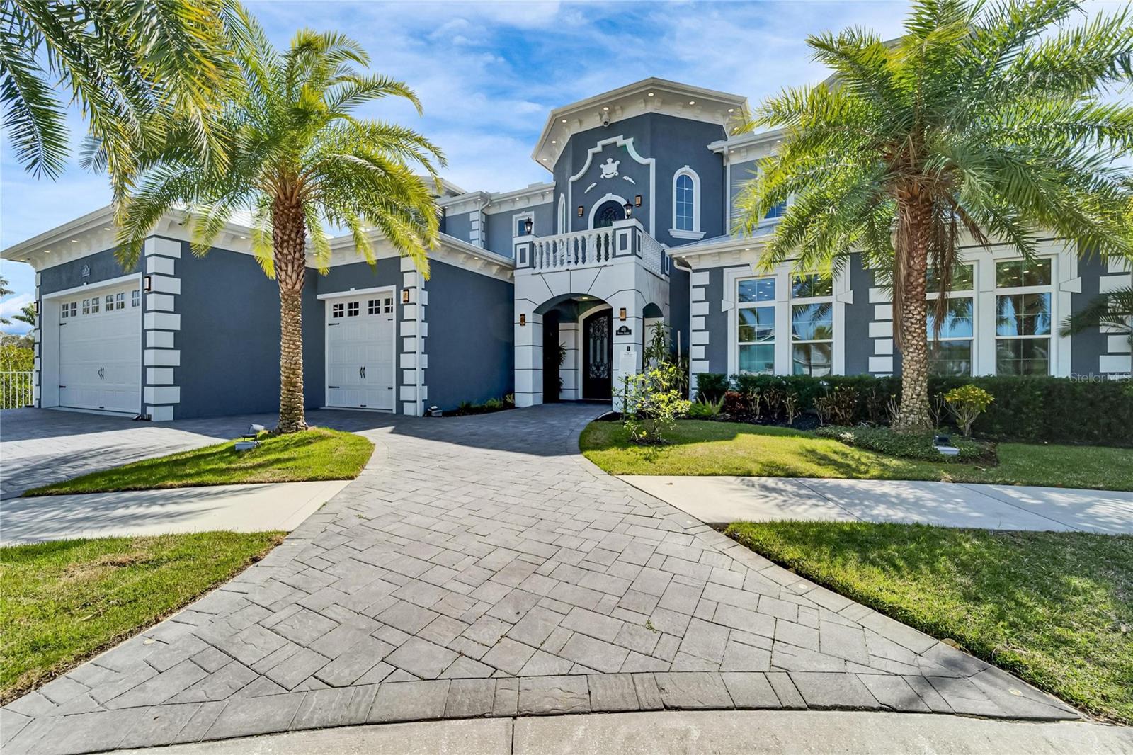 This extraordinary waterfront estate at 401 Bahama Grande Blvd in Apollo Beach is a one-of-a-kind masterpiece offering over 8000 sqft of meticulously designed living space. Located in a gated community on a quiet cul-de-sac, this home offers 270-degree water views and over 147 feet of waterfront frontage with direct access to Tampa Bay. Adjacent lot can be purchased separately.

Builders own personal home has been Built with solid block construction on all floors and cement flooring on each level, this estate is engineered for strength and peace of mind. Hurricane-impact-rated windows and doors, a seamless metal roof, and a cement perimeter provide exceptional storm protection. The expansive dock features WiFi, security cameras, an outdoor shower, and three covered boat lifts (14k lb, 10k lb, and 10k lb). Ownership extends far into the canal, further enhancing this property’s value.

Step inside through grand double doors to a stunning entryway with a custom airbrushed 30-foot ceiling, an elevator for seamless access to all levels, and a curved marble staircase adorned with chandeliers. The three-story great room showcases a dramatic fireplace and a glass wall overlooking the infinity-edge pool with a knife-edge design, slide, diving board, and hot tub. The expansive outdoor living space offers an 18x18 outdoor kitchen with a grill, smoker, pizza oven, sink, ice machine, and refrigerator—perfect for waterfront entertaining. The adjoining lot is available for purchase with a landscaped yard which includes a sports court, playground area, inground trampoline, and cozy firepit.

The gourmet kitchen is equipped with custom quiet-closure cabinetry, high-end Dacor appliances, a built-in Miele espresso machine, a gas cooktop, and a full butler's prep kitchen with a separate refrigerator and coffee bar. A custom glass-enclosed wine cellar with room for 100 bottles serves as a striking showpiece. 

The first-floor primary suite is a private retreat with breathtaking water views, a spa-inspired bath with illuminated custom mirrors, automatic heated toilets with bidets, dual showerheads, an oversized jetted tub, and an expansive custom-built dressing room with an island featuring custom storage solutions. Two additional guest bedrooms have private full baths, including jetted tubs. A third and 4th guest bedroom features a fully tiled bath and custom closets. The media room offers a world-class cinematic experience with a Sony 4K projector, a 120-inch screen, 11.1 surround sound, reclining massage chairs, and a dazzling starlight ceiling. Adjacent to the theater room, a full bar with walk-out balcony access creates a perfect entertainment space.

The third floor boasts yet another private suite with a spacious balcony.

This smart home features automation with Amazon Alexa and iPad control for security, lighting, sound, pool settings, video/TV, front door access, and irrigation. The custom lighting control system extends to both the home’s interior and exterior. Full landscape lighting with an outdoor sound system enhances the ambiance. Sixteen audio zones with over 32 speakers allow customized sound throughout. The home is partially powered by an owned solar system  with an automatic 48k LP generator for added efficiency and safety. Additional highlights include a six-space indoor garage with audio, security, and an EV charger, plus a spacious 40ft x 40ft drive.
