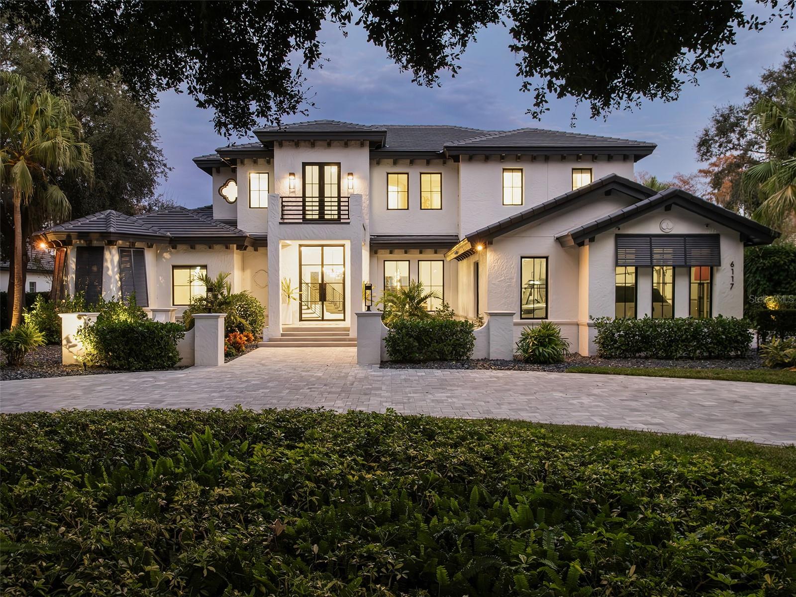 Under contract-accepting backup offers. Nestled along the shores of Lake Louise within Isleworth West, this exceptional two-story estate represents the finest in lakefront living. Offering four bedrooms, four-and-a-half baths, and more than 5,700 square feet of living space, the residence has been fully reimagined with sophisticated, modern finishes throughout. Recent enhancements include a new roof, windows, and doors; an all-new boat dock including a new roof; a new summer kitchen; exquisite white marble flooring, a dramatic glass-and-iron double-door entry, sleek modern air vents, and a host of elevated appointments that create a seamless blend of style and comfort. Grand living spaces—including the living room, kitchen, and family room—all feature soaring ceilings and an abundance of natural light, providing an ideal backdrop for both elegant entertaining and everyday living. The first-floor primary retreat is a true sanctuary, featuring a spacious bedroom and private sitting room divided by a stunning double-sided fireplace. A secondary primary suite, also located on the first floor, offers exceptional privacy and flexibility for guests or multigenerational living. Outdoors, the estate embraces its idyllic lakefront setting with a resort-style pool, summer kitchen, and private boat dock offering direct access to Lake Louise—perfect for boating, sunset cruises, and lakeside leisure.  This is a rare opportunity to experience lakefront living at its finest in one of the community’s most coveted settings.
