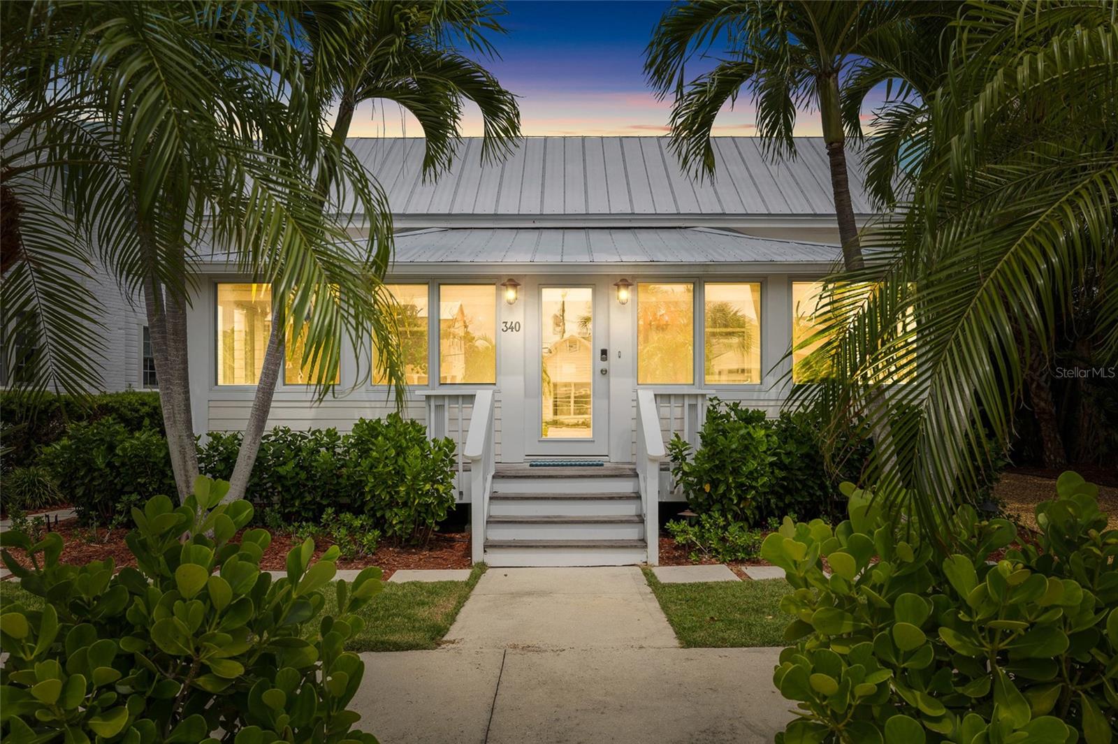 Nestled in the heart of Boca Grande’s coveted “Historic District”, this enchanting two-bedroom, two-bathroom, plus bunkroom Palm Cottage built in 1906 has been thoughtfully reimagined with refined designer finishes and modern conveniences throughout. As you walk up to the property you are greeted by lush tropical landscaping, offering both privacy and vivacious natural beauty. Inside, the front sitting room and dining area is bathed in natural light, creating an inviting space equally suited for tranquil mornings or intimate gatherings with family and friends. At the center of the home, the living room and kitchen blend effortless comfort with understated sophistication. An open-concept design is enhanced by custom built-ins, a charming reading nook, and a generous central cooking island – ideal for entertaining. Overhead, a beautifully crafted tongue-and-groove stained wood ceiling adds warmth and architectural character. The primary suite serves as a serene retreat, complete with a spacious walk-in closet and a spa-inspired en-suite bath featuring a beautifully appointed shower. French doors open directly to the rear porch, inviting seamless indoor-outdoor living. The backyard presents a rare opportunity to curate your own private oasis, with ample space to envision a pool, pavilion, or thoughtfully designed entertaining terrace. This exceptional cottage captures the essence of Boca Grande living – timeless, relaxed, and effortlessly elegant. Both an addition and pool/spa have been professionally designed for the Property. The Cottage is Rental Ready and has excellent rental history! Schedule your private showing today and experience this Cozy Cottage firsthand.