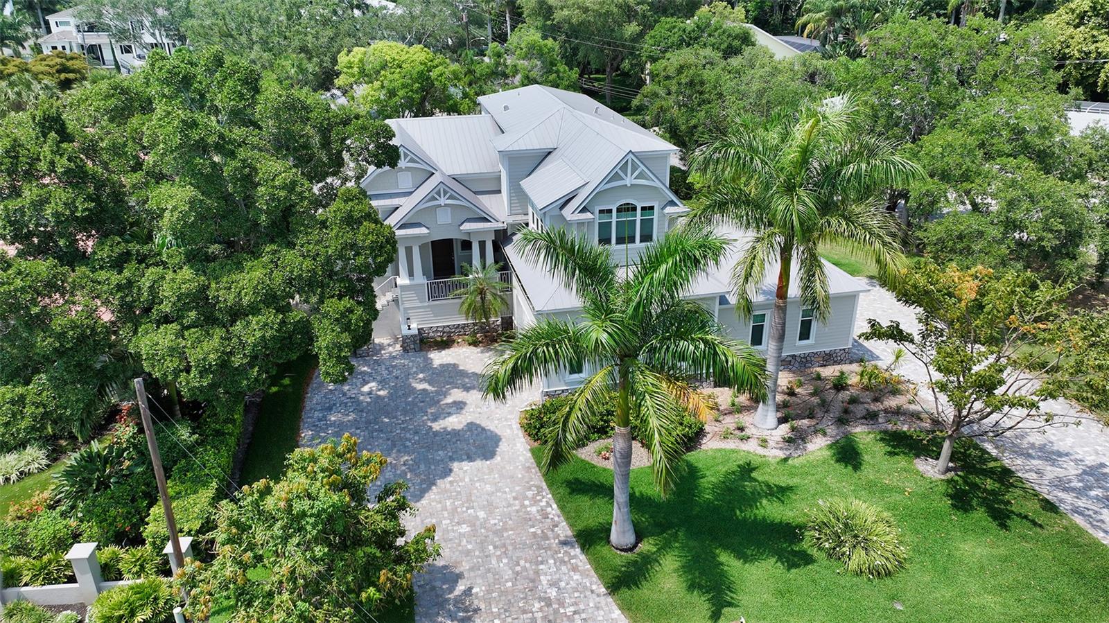 This stunning West of The Trail 4BR/4BA plus office and bonus room with gas heated pool residence from Award winning Allegra Homes offers the expanded two-story “Gloria” model complete with an elevator. Coastal and casual elegance describe this light and beautiful home with 20 ft. beamed ceilings. Engineered hardwoods are featured on the main living area which seamlessly flows into the spacious chef’s kitchen. The kitchen boasts custom light neutral wood cabinetry with light subway back-splash, top-of-the line appliances, 5 burner Wolf gas range and oven with a gorgeous azure mosaic tiled backsplash, a Sub-Zero refrigerator, Asko dishwasher plus quartz countertop space and quartz island with room for many barstools and a separate large dining area with Sub-Zero wine cooler. Spacious walk-in pantry that offers lots of storage. The laundry room with pet door features Maytag washer and dryer. Bring your groceries up in the elevator from the 4 car garage which features beautiful custom built-in cabinetry and Epoxy flooring.  This 3,569 square foot residence affords you all the luxury features of comfort and convenience. Primary Bedroom Suite is located on the main floor. Beautiful Home Office on main living area also. Included is the whole-home on-demand hot water system and a whole-home natural gas Kohler generator system that assures you of electricity during any storm caused power outages.  Three HVAC systems in the residence and Central Vac. There are features like incredible work-of-art ceilings, stone-backed wall behind the six ft. electric fireplace, great room with wall of PGT windows and sliders. The 75 inch TV and speakers above the fireplace stay with the home. Surround sound also featured in the main living area. The spacious principal en-suite bedroom is on the main floor and features two over-sized walk-in wardrobes with shadow box shelving for storage of many accessories. The master bathroom features double vanities with quartz countertops, a large walk-in shower with dual shower heads and you can also pamper yourself in the designer free-standing soaking tub. There is an incredible home office with wet bar and Sub-Zero wine cooler, quartz countertops and beautiful backsplash, cabinetry and drawers on the main floor with a wall of sliding doors looking out to the fabulous 492 sq ft of covered outdoor living space with the gorgeous pool and spa. Two Adirondack chairs, a table, two Frontgate rafts with holder stay with the pool. The summer kitchen by the pool features Lynx grill, beverage refrigerator and cabinetry. The TV on lanai stays with the home as well as the beautiful long dining table and chairs and the firepit with four comfortable swivel chairs. This is a beautiful outdoor area where you can enjoy special occasions with family and friends. The second level features an en-suite bedroom and two guest bedrooms that share a beautiful bathroom featuring quartz countertops and a stunning vertical waterfall of mosaic tiles. The bonus room features two beautiful sunbeds and pillows that remain with the home.  This home is convenient to top rated Southside School, world-class shopping and dining, near the vibrant Southside Village and the arts and entertainment of near-by downtown and Sarasota Memorial Hospital and award-winning beaches! Call today for your own private showing.
