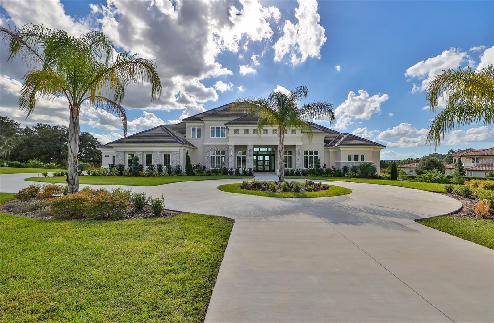 Great opportunity to own a Stunning NEW luxurious, waterfront property in one of Tampa's most premier communities, Stonelake Ranch! This beautifully designed, contemporary home is on 3+ acres of land, has six bedrooms, six bathrooms, six car garage, several walk-in closets, built in safe, two living rooms, dining room, den/office, indoor laundry room, walk in pantry, huge loft area, gas burning fireplace, walk out basement, media room, an outdoor kitchen near the pool/spa, boat ramp and boat/jet ski lift. As you enter through the front doors of your contemporary style home, you immediately have an amazing water view of Lake Thonotosassa, your private pool and spa. The family room/dining room combination has a wood burning fireplace, beautiful chandeliers and access to a breakfast bar that boasts a sink and wine refrigerator. The gourmet kitchen features stainless steel appliances, an oversized island, two wall ovens and a walk in pantry. While in the kitchen, you can still enjoy the water views of the lake, pool and spa. Beyond the kitchen, you can relax in the living room. The retractable glass doors in the living room, afford you the benefit of feeling like you are outdoors, while still being indoors. The covered outdoor space has an outdoor kitchen and is large enough to host family/friends and has direct access to the guests full bathroom. If you choose to host family/friends inside, don't worry, this home has the perfect space for this in the walk out basement. The basement has a theater room, game area, space for a gym, full bedroom, bathroom, sink and wine refrigerator. Your guests can access the basement from either the inside of the home or through the sliding glass doors under the covered lanai. The oversized primary suite has a sitting area, two customized walk in closets, access to the covered lanai and an en-suite bathroom. The enormous primary bathroom is a perfect place to relax. It has separate sinks with vanity space, stand alone garden tub and a walk around shower. The primary shower features several shower heads, built-in sitting bench and a rain shower.
As you walk upstairs, you encounter a huge loft area that can be used for another living room, play area, or workspace. There are also three bedrooms upstairs. One room has an en-suite bathroom and the other two rooms have Jack and Jill bathroom. 
The air-conditioned six-car garage is on the side of the home. The garage has stairs that lead to another space that could be used for storage, an extra closet, room or studio.
The community has 24-hour guarded gate, fitness center, exclusive events for residents, and access to the clubhouse.
The only thing missing from the community is you. Make an offer today. Bedroom Closet Type: Walk-in Closet (Primary Bedroom).
