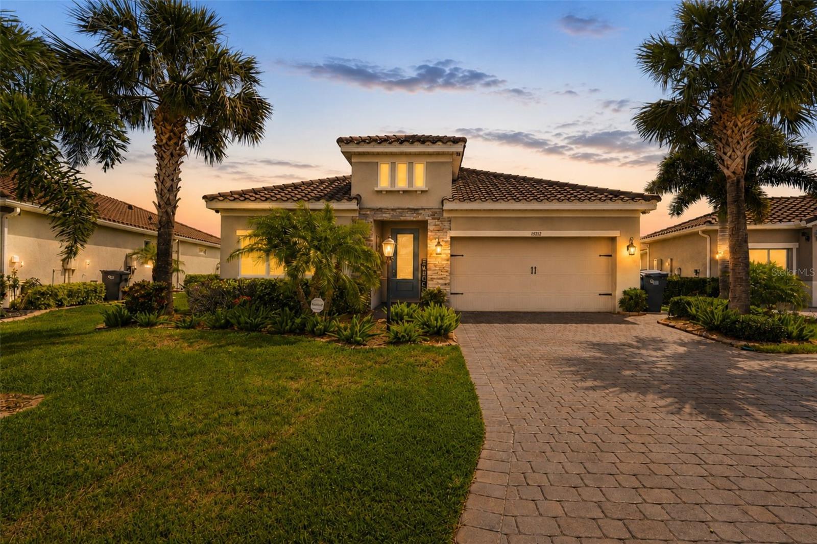 Experience refined Florida living in this beautiful pool home, ideally positioned within the gated community of Savanna at Lakewood Ranch and served by a highly regarded school district. Savanna offers resort-style living with a stunning clubhouse featuring a beach-entry pool, lap pool, and spa, a state-of-the-art fitness center, spacious dog park, open fields for recreation, cabana pavilion, shaded playground, pool with interactive water features, an event/play lawn, open greenspace, and walking trails that meander throughout the community. Lawn maintenance is also included in the HOA, making for a truly maintenance-free lifestyle.
A striking stone facade, classic tile roof, elegant glass front door, and inviting curb appeal create an impressive sense of arrival from the outset. High-efficiency double-pane windows enhance comfort, energy savings, and peace of mind, while thoughtful upgrades throughout the home create a warm, polished setting for everyday living and effortless entertaining. Inside, tray ceilings, tile flooring across the main living areas, and soft bedroom carpeting offer a balanced blend of style and comfort. The spacious formal dining room sets the stage for memorable gatherings, holiday meals, and special occasions, while also offering the versatility to function beautifully as a private den, office, or flex space. The comfortable great room delivers an open, welcoming atmosphere, ideal for relaxing with family, hosting guests, or enjoying a quiet evening at home. The kitchen is designed to impress with warm wood cabinetry, granite countertops, a sleek backsplash, stainless steel appliances, recessed lighting, a free-standing gas range, and modern triple pendant lighting above the island. Whether preparing a casual breakfast, cooking for guests, or gathering around the heart of the home, this kitchen blends function, comfort, and style. The primary suite offers a serene retreat with a spa-inspired bathroom featuring a free-standing soaking tub and a separate glass-enclosed shower. Its thoughtful layout creates a relaxing space to begin and end the day, while elevated finishes add an inviting sense of elegance and comfort. Additional bedrooms with soft carpeting provide welcoming spaces for family, guests, hobbies, or quiet relaxation. Outdoor living is where this home truly shines. Enjoy the Florida lifestyle from your private pool area, complete with a multi-colored pool light and new pool pump, both conveniently controlled by phone. An outdoor ceiling speaker adds the perfect touch for unwinding by the water or entertaining friends. Additional features include a security camera, automatic front lighting system with seven lights, hurricane shutters, a whole-house generator, and an exterior gas stub ready for a future outdoor kitchen. With smart upgrades, desirable community living, and a strong school district setting, this home offers comfort, style, security, exceptional Florida living, and lasting value.