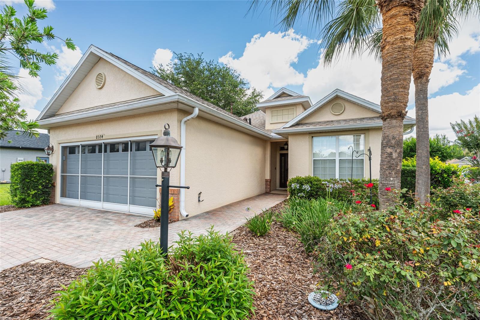 Welcome home to this meticulously maintained extended Westross model on a spacious corner lot just a short walk from the Candler Hills Golf course and Clubhouse Restaurant at On Top of the World Ocala's premier 55+community.  When you arrive at this home there is a paver driver and extended garage and  you enter through the front porch.  The guest bedroom and bathroom are to the right of the front foyer and across the hall from the flex room den or office with french doors to use as  space for relaxing or a work from home office with privacy.  The guest bedroom has a closet with ample storage and a linen closet is near the guest bathroom with tub and shower.  The floors throughout the house in the living areas are wood laminate and tile in the bathrooms and foyer.  The primary bedroom suite has an ensuite bathroom with double vanity sinks and has a walk in closet with custom cabinetry and linen closet as well as a large shower and separate toilet area.  The primary bedroom has an added sitting area for reading a book or watching TV or relaxing to add to the privacy of the primary bedroom suite.   The open floor plan in the dining room and living room have 9'4" ceilings looking out into the enclosed lanai with windows and screens and sliding glass doors.  Surrounded by mature landscaping with trees, shrubs and flowering plants to enjoy sitting in the lanai as a relaxing added space for all seasons.  All of the rooms have ceiling fans and wooden shutters on each window which add to the character of this lovingly cared for home.  The kitchen has an eat in breakfast bar to enjoy your morning coffee.  There are  newer stainless steel appliances (2024) including a gas range, refrigerator and new microwave next to the spacious pantry for convenient storage in the kitchen. A new roof was completed in 2023 and the AC and gas furnace were replaced in 2021.  Come home and enjoy all of the upgrades in this  home in a wonderful well established Candler Hills neighborhood where you own your own land. The only thing missing is YOU!