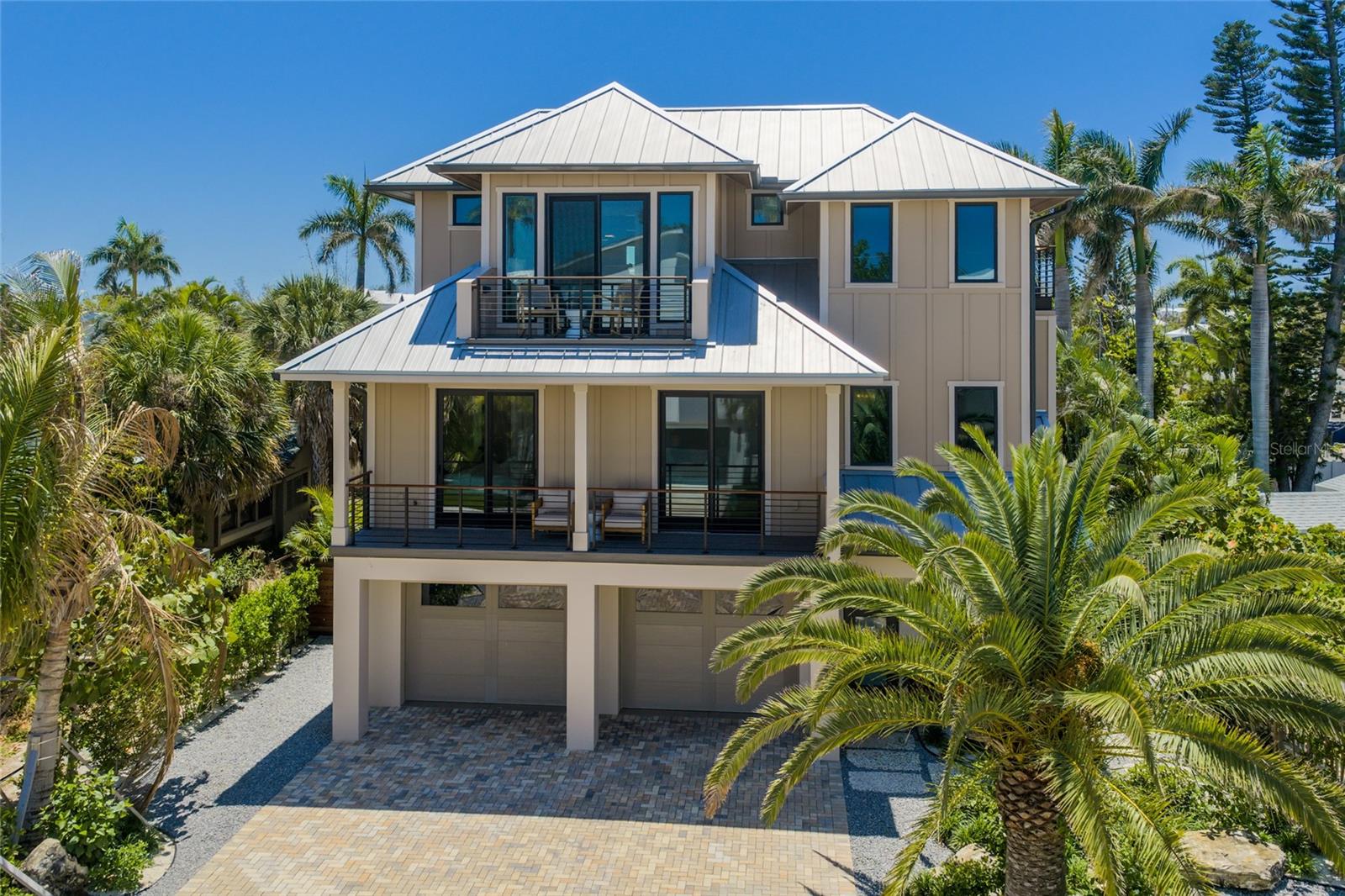 Welcome to The Beachwood!
Discover coastal elegance in this brand-new constructed home with elevator on the coveted North End of Anna Maria Island.  
This exceptional 4-bedroom, 4-bathroom home offers the ultimate island lifestyle with contemporary elegance and breathtaking views. Boasting a private heated saltwater pool & spa surrounded by tropical palms, multiple spacious balconies, and a ooftop deck with spectacular views of the Gulf, this home is designed for effortless entertaining and unforgettable sunsets.  Inside you will find a spacious open living area with a chef’s kitchen including high end Thermador appliances, bar with a wine and beverage fridge, and cozy fireplace to relax. Tastefully furnished and decorated with calming colors and natural materials, this open design also allows for plenty of natural light and inviting views of the mature tropical landscape.  Enjoy the beauty of the custom wood features in the home like the live edge teak mantel, and the upstairs coffee and beverage bar cut out of Brazilian hardwood.  You can read and study in the privacy of the office with built-in bookshelves or relax outside the office on the balcony.   Either side of the home features custom IPE wood and metal gated fences for luxuriousness and ultimate privacy. There’s a large two-car garage with plenty of storage space.  The home is secured with impact and hurricane sliders and windows.  Perfectly situated between the beautiful beaches of Bean Point and Pine Avenue, you’re just steps away from serene bayfront beaches, restaurants, boutique shopping, and waterfront recreation.
Whether you’re relaxing in the spa after a day at the beach or hosting friends on the rooftop with panoramic vistas of Tampa Bay and the Skyway Bridge, every detail invites you to unwind in paradise.
Schedule your private showing today!