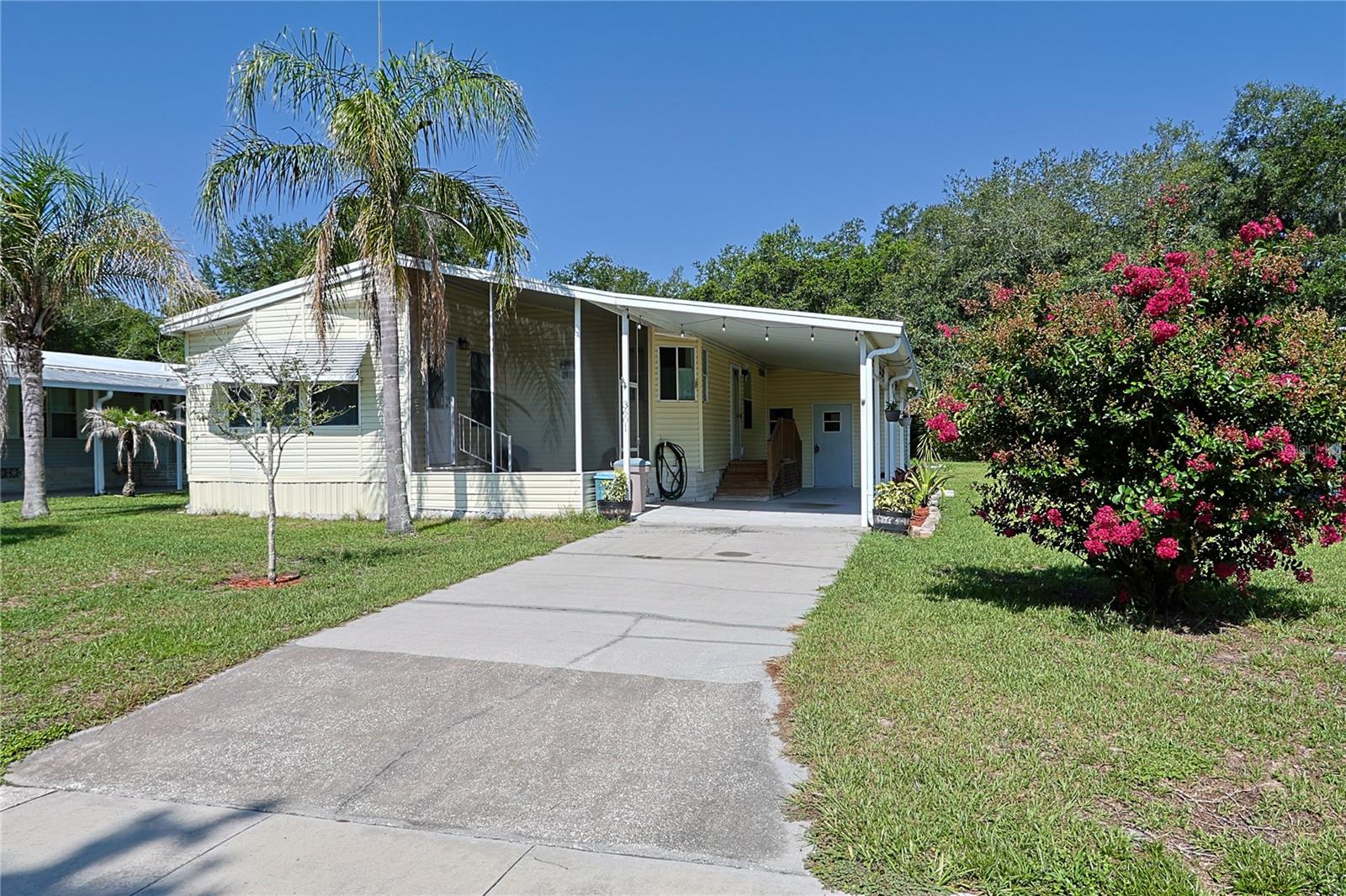 Enjoy the Florida lifestyle in this quiet, well maintained, 55+ community.  This beautifully updated home is move in ready and it comes fully furnished, if you desire!  The primary bedroom is spacious and features an en-suite bathroom with a beautiful wood barn door. The living area is open and bright and there is even a bonus room to make your own as a study, game room or sunroom. The kitchen features plenty of cabinets and counter space, a Samsung refrigerator with the freezer on the bottom, and a large slide-out pantry.  Just steps outside under the carport is an spacious enclosed laundry room.  There is even a workshop with electric out back! The roof was replaced in 2015, the HVAC in 2021 and the plumbing in 2022.