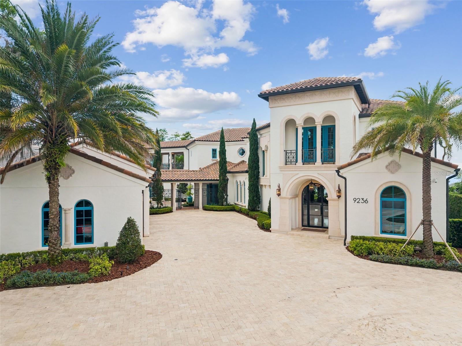Lake Front, this home comes furnished, within the gated community of Bay Point in Bay Hill, this lakefront estate offers a rare combination of luxury, comfort, and waterfront living on Lake Tibet, part of the renowned Butler Chain of Lakes. Designed to capture beautiful lake views throughout, the home blends elegant architectural details with spaces that feel warm, open, and inviting.
From the moment you arrive, the stone driveway, impressive architecture, and 4 car garage create a strong first impression. Inside, the custom glass entry opens to soaring ceilings, designer fixtures, a grand staircase with glass railing, and dramatic floor-to-ceiling windows that immediately draw your eye to the lake. The open floor plan is ideal for both everyday living and entertaining, with seamless flow between the main living areas and outdoor spaces.
With nearly 10,000 square feet, the home offers exceptional flexibility for family and guests. The layout includes two spacious primary suites, one on each level, two additional en-suite bedrooms in the main residence, and a private guest apartment with its own suite. Additional features include maid’s quarters with a walk-in closet and full bath, private gym, sauna, elevator, and a stunning wine cellar that wraps around the staircase.
The gourmet kitchen serves as the heart of the home, featuring top of the line appliances, an oversized quartz island, custom cabinetry, and a hidden pantry door leading to a large walk-in pantry. Large accordion doors open the kitchen and living areas to the covered lanai, summer kitchen, and resort-style backyard.
Outside, the lakefront setting is exceptional, with an infinity edge pool and heated spa, outdoor entertaining areas, touchless curtains, covered dock, one boat slip, and two ski lifts. Lake Tibet is one of 13 lakes that make up the Butler Chain of Lakes, offering approximately 5,000 acres of water surface for boating, skiing, and Central Florida lakefront living. Bay Point residents also enjoy community amenities, including a pool and clubhouse, all with convenient access to dining, shopping, top rated schools, major highways, Orlando International Airport, and Lake Nona Medical City.