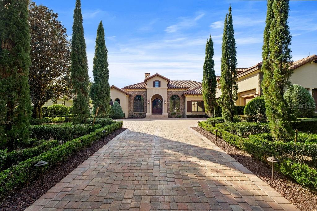 Exceptional Waterview Estate in Keenes Pointe / Resort-Style Outdoor Living.

Located on a quiet cul-de-sac in the exclusive guard-gated community of Keenes Pointe, this custom Goehring & Morgan residence offers luxurious main-floor living paired with spectacular outdoor entertaining spaces and tranquil water views.

Designed for both comfort and entertaining, the home features a heated saltwater pool with travertine decking, expansive covered lanai with automatic screens, summer kitchen, fire pit, fenced yard, and breathtaking sunset views.

Inside, enjoy soaring ceilings, travertine flooring, custom millwork, 10-ft sliding doors, a wine cellar, hidden walk-in pantry, and a chef’s kitchen with Wolf 48” gas cooktop and custom cabinetry. The main-floor primary suite offers lanai access and a spa-inspired bath, while three additional bedroom suites are also conveniently located on the first floor.

A spacious upstairs bonus/game room with full bar creates the perfect media, entertainment, or multigenerational flex space.

Additional highlights include:
• Oversized 3-car garage
• 4 HVAC units + dehumidifier system
• Updated pool equipment (2022)
• Elevated garden shed + premium Vego garden beds
• Office with custom built-ins

Residents enjoy access to the Golden Bear Club lifestyle with golf, tennis, fitness, dining, Butler Chain lake access, and proximity to Windermere Prep, Disney, and Universal.

Some photos have been virtually staged. Furnishings shown are for illustrative purposes only and are not included in the sale.