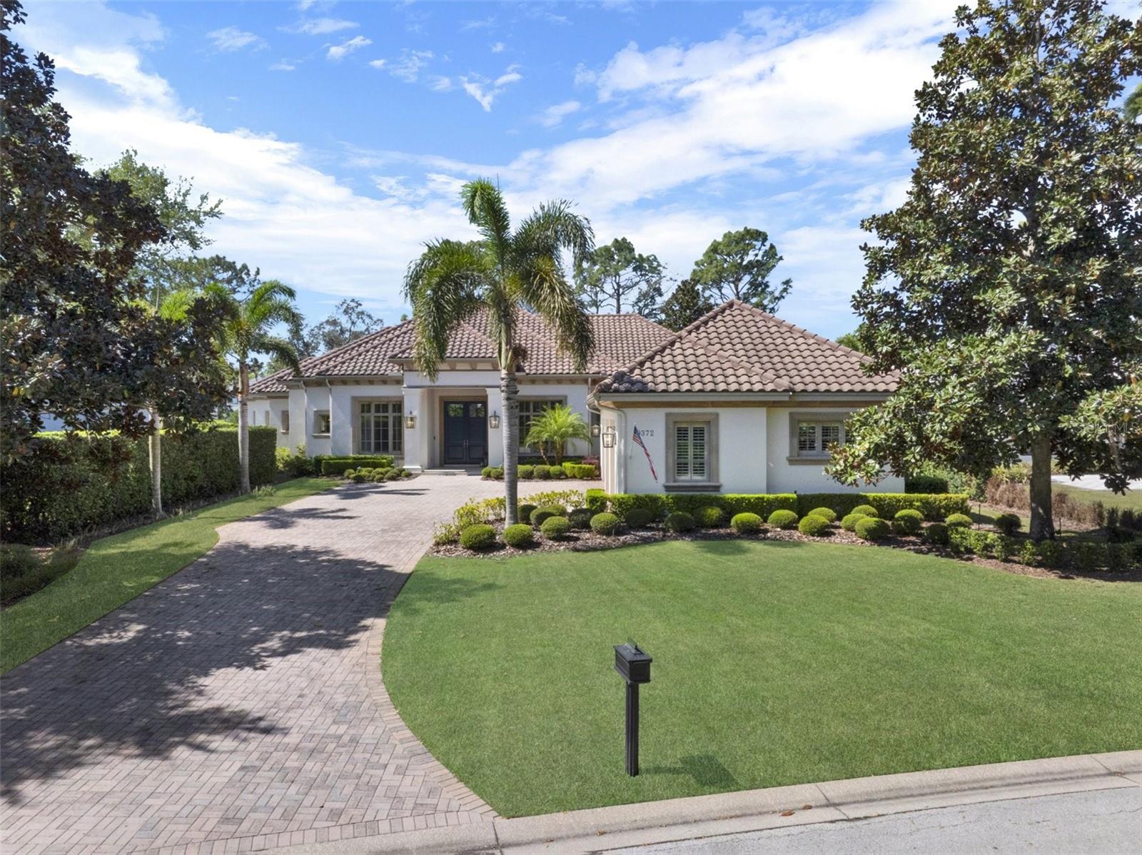 Privacy, Outdoor Living at its finest, One-Level, Open, Split Floor Plan, Incredible Flow, Tremendous Natural Light, Water & Conservation views, these are a few of the wonderful characteristics of this beautiful, custom-built estate by Maroon Fine Homes in 2009. This meticulously maintained home features almost 5,200 SF of living space, 4 bedrooms, 4.5 Baths, a Dedicated Office, Bonus/Game Room with Wet Bar, 3-Car Garage, a plethora of outdoor living space, and Private Pool & Spa, all situated on nearly 0.5 acres on a double-ended cul-de-sac street. Enjoy the Mediterranean style as you pull up the front paver driveway and see the stone-wrapped columns at the front entry, clay barrel tile roof and mature, lush landscaping. Everyone will be impressed when entering the double, front doors and see straight through the huge pocket glass sliding doors to a beautiful pool & spa. The incredible outdoor oasis features 1,259 SF of covered, screened-in living, a gas fireplace, Summer Kitchen and numerous areas for relaxing, entertaining and watching stunning sunsets over the glistening pond. This split plan offers the perfect layout, on one side of the home there is the primary suite, an office, secondary bedroom and the powder bath. On the other side are two bedrooms with en-suites and laundry and in the back is the open concept kitchen, living area with bonus room! The oversized primary retreat is serene and tranquil with views of the pool and its own private access to a covered area. It also features a sitting area, a built-in dry bar with an undercounter refrigerator, gorgeous ceiling trim detail, a huge closet with custom built-ins and its own washer and dryer for convenience. The oversized primary bath has separate vanities, a beautiful built-in tub with pond views and a large shower adorned with gorgeous accent tiles throughout, beautiful custom light fixtures and wallpaper! The half bath has a custom vanity with stunning tiles and accent lights, which also has access out to the pool oasis. The second bedroom with private en-suite has views of the front yard. The dining room opens to a wet bar and features an exquisite chandelier, highlighted by the unique ceiling details. Beyond the bar is the kitchen, family room and eat-in kitchen area, that flow seamlessly, perfect for entertaining. The gourmet kitchen features a large bar offering tons of seating areas.  There is also an oversized island with a gorgeous linear chandelier. The top of the line, built in appliances and custom floor to ceiling elegant cabinets create a beautiful and practical space for any chef. Additionally, there is a hidden pantry. The family room has a beautiful built-in wall unit for the TV and audio equipment. The ceiling also features a one-of-a-kind detail showing off the high ceilings. Beyond the family room is the bonus room with beautiful, coffered ceilings and a wet bar. This room has sliding doors with access to the summer kitchen and pool area. There is tremendous natural light offered by a huge window overlooking the beautiful landscaping and pond.This exclusively private, 24 hour guard-gated, renowned Lake Nona Golf & Country Club home offers more than just a lovely home…it offers a “lifestyle;” one filled with family, friends, golf, lake living and privacy. All A-rated schools, within minutes of Orlando’s Intl Airport, Lake Nona’s Medical City, Boxi Park, USTA & situated between the 417 Greeneway & 528 Beachline. Don’t miss out on this unique opportunity!