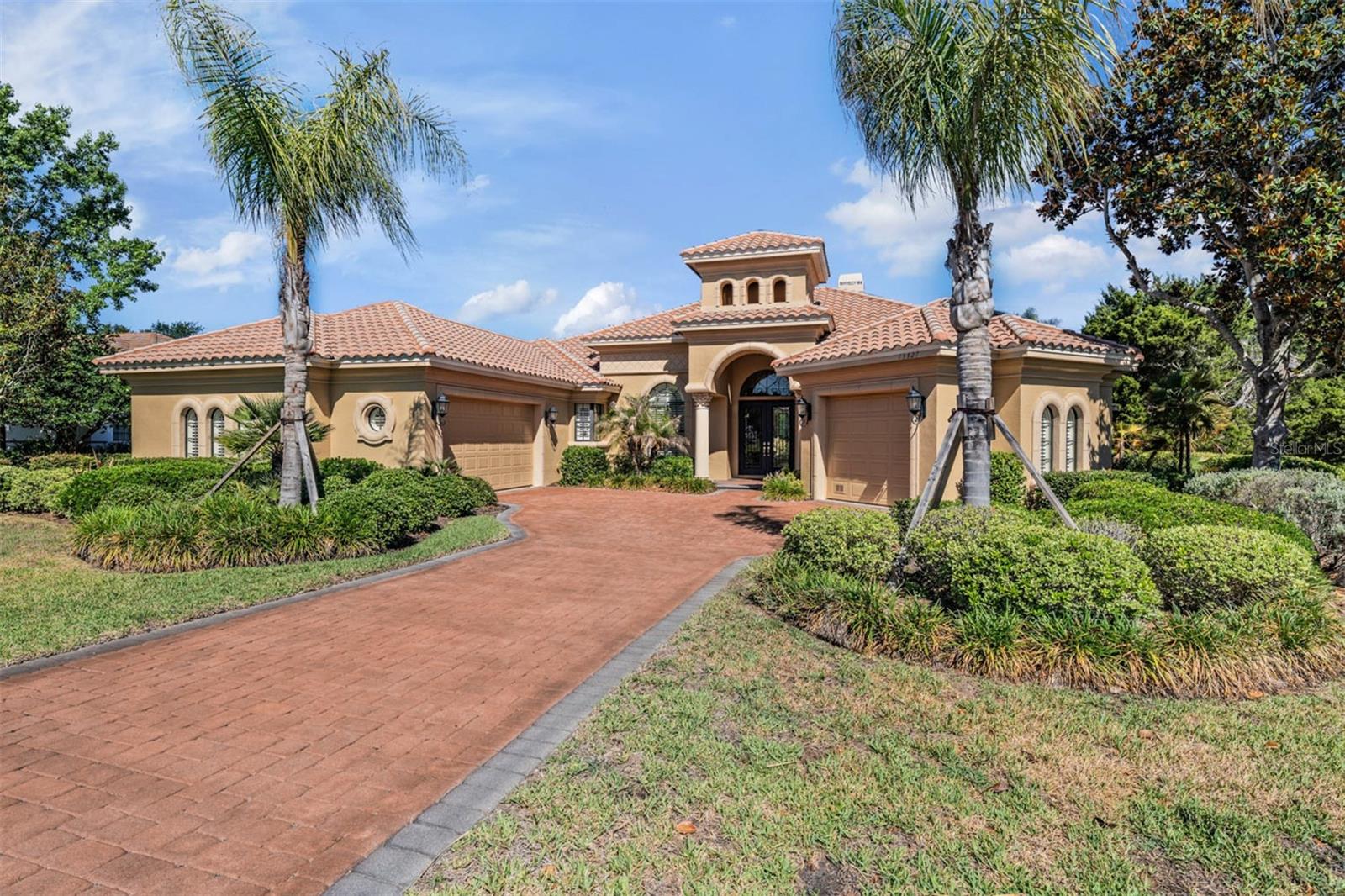 EXQUISITE and professionally decorated, this exceptional Arthur Rutenberg previous Model home is being offered fully furnished with over $85,000 in Furnishings and showcases the highly sought-after Laguna floorplan with 4 bedrooms plus a private office. Perfectly positioned in the Rolling Hills of East Pasco, in the Security guard gated community of Lake Jovita Golf & Country Club, the residence captures breathtaking panoramic views of the 14th hole on the North Course, majestic grandfather oaks, serene ponds and beautifully manicured fairways. From the moment you arrive, the paver driveway, impeccable landscaping, and timeless architectural design set the tone for the luxury found throughout. Expansive walls of glass across the rear of the home flood the interior with natural light while blending indoor and outdoor living spaces designed for both grand entertaining and everyday living. Private serene views with No neighbors in sight for a private retreat! Wooden Millwork accents, double, wide crown molding, tray ceilings and stunning sunsets in this thoughtfully updated and meticulously maintained, extraordinary home featuring newly painted interior and exterior, a 2025 AC system, 2025 water heater and refrigerator, 2024 Pentair pool pump, owned water softener and two gas fireplaces supported by a buried gas tank. The spectacular outdoor oasis has been elevated with a $20,000 ICONIC glass pool remodel showcasing a stunning spillover spa, saltwater system, multi-speed pool equipment, and an expansive paver pool deck. The covered lanai creates a true resort-style experience with an outdoor fireplace, built-in gas grill with exhaust hood, and tranquil golf course views, just off the flex room set up as a gameroom! Inside, refined finishes and quality craftsmanship are evident throughout the spacious floorplan, which includes a formal dining room with Butler’s pantry, elegant living room with fireplace, open-concept kitchen and family room, and an impressive bonus/billiards room complete with wet bar, wine rack, custom cabinets and refrigerator—offering the flexibility to serve as a fourth bedroom or private entertainment retreat. The oversized gourmet kitchen is beautifully appointed with 42-inch wood cabinets, breakfast bar, built-in convection oven and microwave, cooktop, dishwasher, and a charming breakfast nook overlooking the pool and golf course. The luxurious primary suite offers a private sitting area and dual custom walk-in closets, while the spa-inspired ensuite bath features double vanities, a Jacuzzi tub, and private water closet. Additional highlights include an oversized three-car garage with epoxy floor and built-in storage cabinets. Residents of Lake Jovita enjoy an unmatched Country Club Lifestyle featuring OPTIONAL memberships including: Social events, Full service restaurant & pub grille, two championship golf courses, Har-tru clay tennis courts, fitness center & resort-style pool with lap lanes. Residents enjoy pickleball & basketball courts, walking trail with exercise stations, playground, picnic pavillion, open fields and dedicated dog parks included in the low quarterly HOA. Conveniently located just minutes from shopping, dining, medical facilities, top schools, I-75, major highways, and two international airports, this extraordinary residence offers the perfect blend of luxury, comfort and country club living. This is a rare opportunity to own one of Lake Jovita's most captivating homes.  CALL TODAY!
