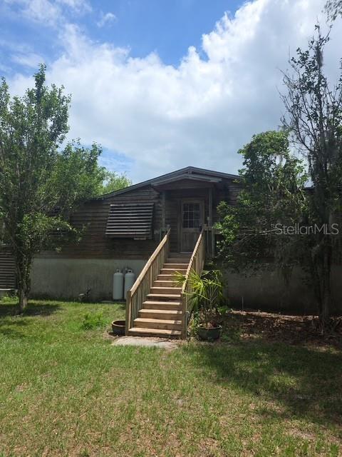 Located in Groveland, this is far from your ordinary mobile home! Nestled on 30 private acres, this unique property offers the perfect blend of functionality, privacy, and outdoor living. Approximately 29 acres consist of scenic wetlands filled with beautiful cypress trees, while the home and all improvements are situated on the one high and dry acre meaning no flood insurance is required.  The property features a deep-water well housed in a dedicated well house with freeze protection, providing crystal-clear drinking water with no staining to sinks, showers, or toilets. The home is set on a solid block foundation with an impressive 88-inch crawl space, allowing easy access to plumbing and electrical systems. The crawl space also includes drainage, a sump pump, lighting, and ample room for use as a workshop or project area.
Exterior upgrades include wood siding with shutters, gutters that drain into a man-made retention pond, covered outdoor storage, and multiple functional outdoor spaces. Inside, the home has been tastefully updated with Hardie Board interior walls, upgraded lighting fixtures, luxury vinyl flooring throughout the common areas and primary bedroom, and updated window blinds. A rustic barn door adds charm and privacy to the French doors leading to the rear deck, which is already equipped with electricity for outdoor lighting and entertainment.

Additional features include a versatile he/she shed previously used as a workout room, a prepared slab with electric and propane connections ideal for an 18-foot above-ground pool or custom firepit area, and an outdoor cooking space complete with a grill, smoker box, electric, lighting, water access, and block walls ready for future expansion.

For RV owners, the property offers full RV hookups and a lift station connected to an oversized septic system. There is also an existing foundation ready for a future pole barn, plus a newer storage shed for all your equipment and storage needs. Fruit trees and clusters of bamboo add even more character and privacy to this one-of-a-kind property.

If you are looking for peaceful country living with room to expand, entertain, and enjoy nature, this property is a must-see!