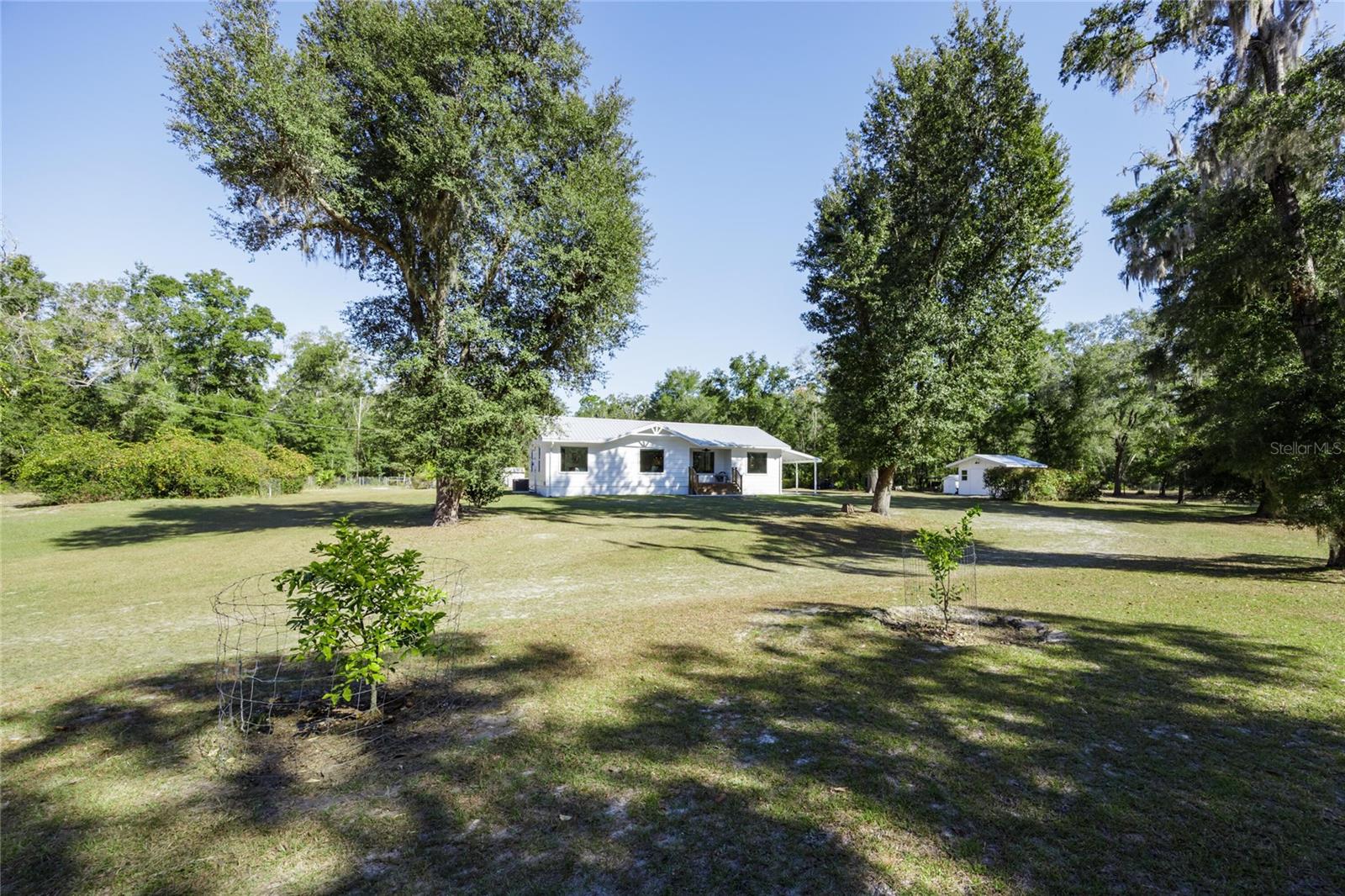 House for sale on 5 ACRES. Remodeled 3 bed 2 bath house on 5 high and dry fenced acres. Beautiful, peaceful country setting. Nice mix of trees and cleared land. Lots of wildlife, perfect hobby farm setting, bring the horses! Remodel and addition permit no. 26-00236.  Energy efficient new windows, appliances, quartz countertops, plywood soft close cabinetry, lvp, newer hvac, "carport," primary suite addition. Metal roof plus energy efficient bubble wrap underlayment installed 2020 permit 20-00832. Septic and drain field are brand new. Permit no. 21-SG-4087495. Survey was done in February. Fruit trees and bushes. Clean well water, no staining on appliances. Sheds. Affordable FIBER internet connected. By the county line, 10 minutes from Publix, in low tax Gilchrist County, low cost utilities, no hoa, free trash drop off, short commute to Gainesville. 5 acre parcel next door available for purchase to make it 10 ACRES. Owner holds Fl real estate license.