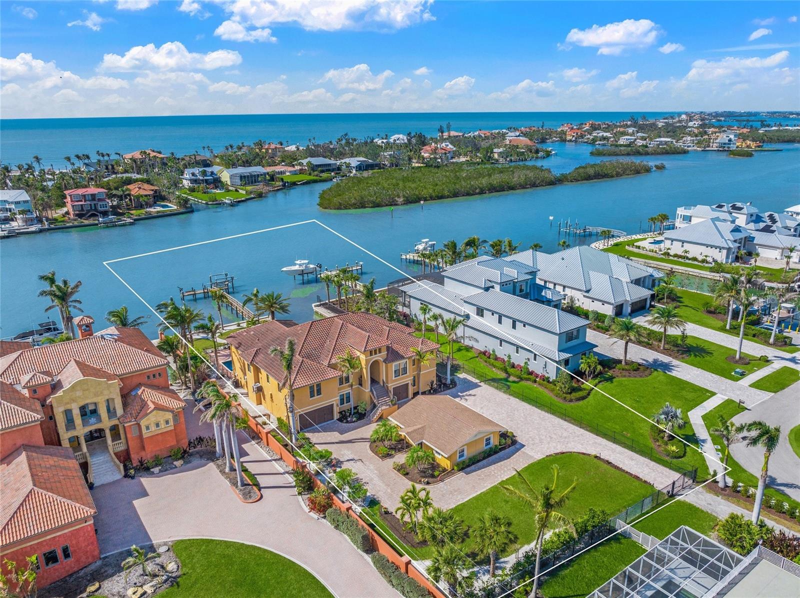 Price Improvement. Built in 2014 by renowned Arthur Rutenberg, this gated Intracoastal Waterway estate includes a fully remodeled two-bedroom guest house.  The main residence offers over 3,500 square feet of one-level living. Featuring an open floor plan with glass walls showcasing wide water views & sunsets. Interior features include 12-foot coffered ceilings in the Great Room, 10-foot ceilings throughout, solid 8-foot doors, impact-resistant windows & doors, elevator, security system, engineered hardwood floors, porcelain tile, & crown molding. The gourmet kitchen includes an oversized island, walk-in pantry, Butler’s Pantry with wine cooler, five-burner gas stove, custom wood cabinetry, & built-in 150-bottle Viking wine refrigerator. All A/C units have been replaced within the last three years, including one in February 2025.
The 783-square-foot Master Suite occupies the north side of the residence & includes tray ceilings, two walk-in closets, large bathroom, & covered lanai access. Adjacent is a custom office with built-ins & Plantation shutters. The south side of the home includes a waterfront library with custom shelving & cabinetry, two additional bedrooms, one en-suite bath, third full bathroom, elevator access, & split-level staircase to the ground floor. Additional features include a large laundry room with new Maytag washer & dryer, custom cabinetry, & Plantation shutters.
Outdoor features include a covered & screened outdoor kitchen with American Outdoor Grill, sink, refrigerator, dining area, heated saltwater pool, large paver deck, dock with water service, a 13,000-pound boat lift and an approved 2nd dock slip The 3,100+ square-foot ground floor offers an oversized three-car garage, multiple storage rooms, bonus room with A/C, full bathroom, & covered lanai access.
The furnished guest house offers an open floor plan, eat-in kitchen, two bedrooms, one bathroom, dual vanities, & private laundry. Situated on a 26,000+ square-foot lot at the end of a private lane shared by only two other homes, the property is located four blocks north of Albee Bridge & across from Casey Key & Nokomis Beach. Convenient access to waterfront dining, shopping, Publix, pharmacy, Post Office, boutique shopping, & other daily conveniences by golf cart, bicycle, or short walk.