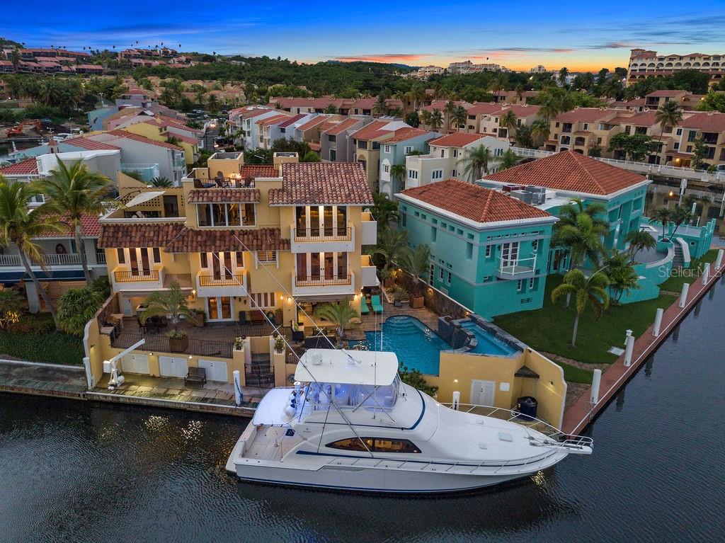 An Iconic Waterfront Residence in Isla San Marco, Palmas del Mar.
Nestled on the waterfront with a 90-foot private dock, this three-story masterpiece redefines luxury living. Step onto the open terrace, where sweeping views of the bay and passing yachts create the perfect backdrop for morning coffee, sunset cocktails, or elegant gatherings with friends and family.
The home features four spacious bedrooms, including a primary suite with a private balcony overlooking the bay and boats, offering a serene retreat at the end of the day. Maintain your wellness routine in a private, fully equipped gym, or enjoy cinematic experiences in a state-of-the-art theater with pristine acoustic sound.

The sparkling pool and Jacuzzi provide serene spaces to unwind, entertain, and fully embrace the waterfront lifestyle.
Currently generating $35,000 per month in rental income, this residence combines unparalleled luxury with an exceptional investment opportunity.
With only 40 exclusive residences in this enclave, enjoy unmatched privacy, prestige, and a truly elevated lifestyle reserved for those who appreciate the art of sophisticated living.