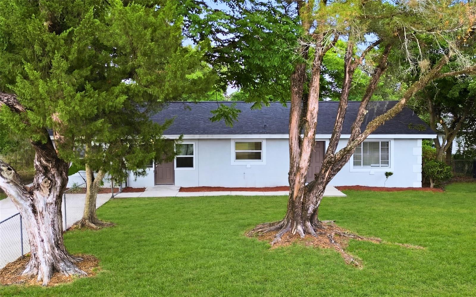 Virtually Staged. Welcome to this inviting single-story home in Longwood, offering a bright layout, spacious rooms, and a large yard surrounded by mature trees. The HVAC was replaced in 2020 and the water heater was replaced in 2021, adding practical updates for peace of mind. From the moment you arrive, the fresh exterior, extended driveway, and peaceful setting create a sense of privacy and possibility. Inside, the home features tile flooring throughout the main living areas, neutral finishes, updated baseboards, arched entryways, ceiling fans, and abundant natural light. The living room offers a comfortable gathering space with large windows and an easy flow into the kitchen and bedroom areas. The kitchen features shaker-style cabinetry, granite countertops, generous storage, a built-in microwave, range, refrigerator, and a window over the sink that brings in natural light. The primary bedroom offers excellent space, a private bath, closet, ceiling fan, and flexible layout, while the additional bedrooms provide natural light, closet space, and options for guests, family, or a home office. Both bathrooms feature tiled finishes, with the primary bath offering a walk-in shower and the secondary bath offering a clean, functional layout. A standout feature is the oversized laundry room, offering impressive bonus space for storage, hobbies, utility needs, or future customization. Step outside and imagine the potential of the expansive backyard, with plenty of room to relax, entertain, garden, or create the outdoor space you have been wanting. Mature trees provide shade and character, while the large lot gives the home a sense of openness that is hard to find. Conveniently located near shopping, dining, schools, parks, and major roadways, this home offers comfort, flexibility, and everyday convenience in an established Longwood setting. Once you walk through it, you can easily see how this home could fit the way you want to live.