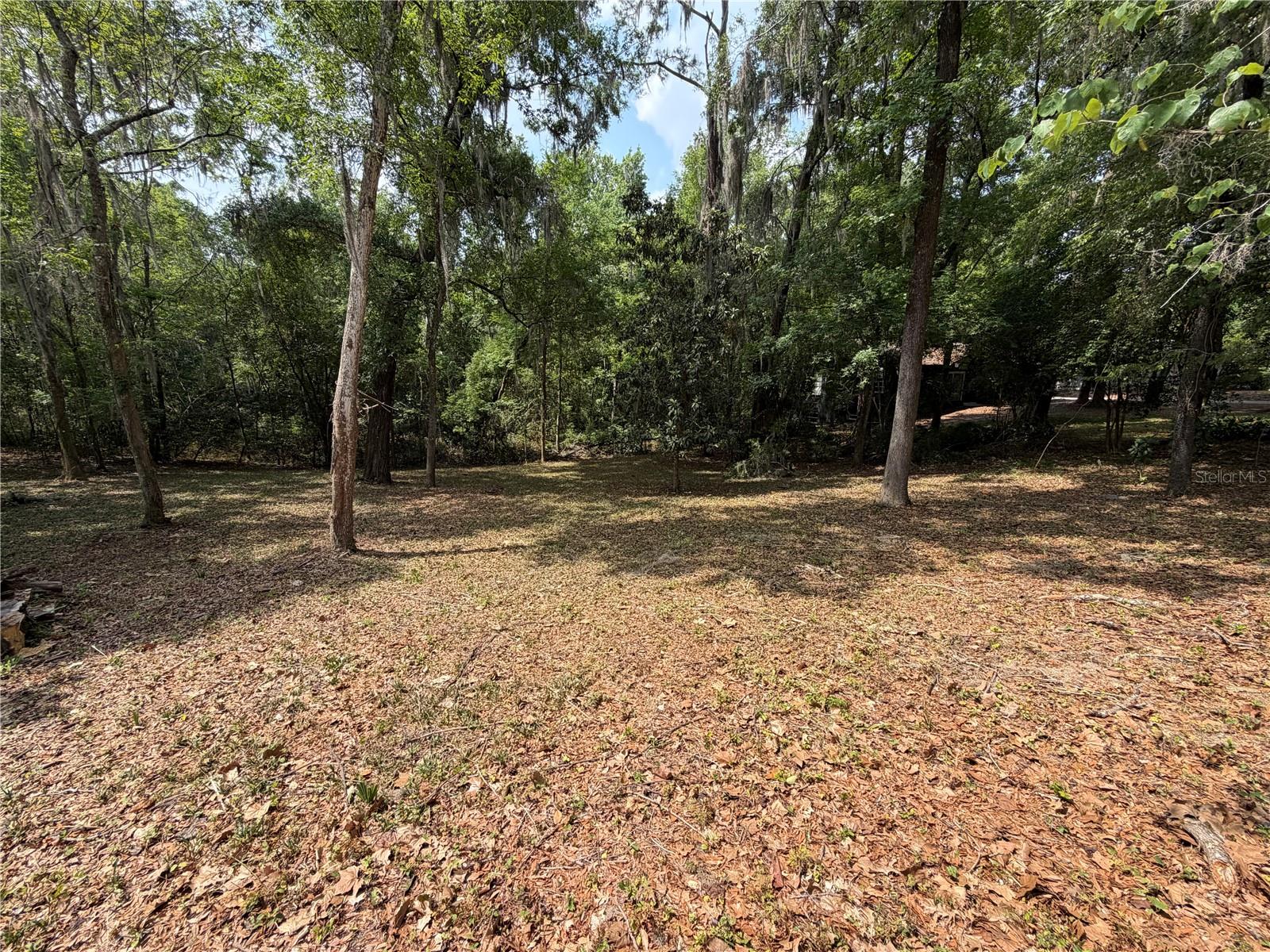 Discover the perfect place for your dream home on this 0.31-acre lot nestled in one of Gainesville's most desirable neighborhoods. This residential Open Builder lot is located in NW Gainesville's Florida Park neighborhood. Exactly one mile from the University of Florida, imagine walking to campus for work or Gator games. The lot measures 135 feet wide and 100 feet deep. The Florida Park neighborhood is a beautiful mix of 1940's, 50's and 60's homes ranging in architectural styles from ranch to Mid-Century Modern and traditional Florida architecture. The sidewalks and close proximity to nearby parks, restaurants and shopping support an active, outdoor lifestyle. Hogtown Creek, mature tree cover and sloping hills make this a very unique setting. Coupled with its close proximity to the University of Florida, UF Health, Downtown Gainesville and Innovation Square, this lot is a rare find. City water, sewer, electric, natural gas, internet and high-speed fiber optic are available. Sellers have a survey, tree survey, topographical survey, soil tests and plans for a custom modern home that blends perfectly into the site. In 2024, the City of Gainesville revised all residential single-family zoning into a common category that allows attached and detached Auxiliary Dwelling Units (ADUs), perfect for multi-family generational living. The lot's rolling hillside, with 10 feet of slow and steady elevation drop from the Northeast to the southwest corners, offers unique views into a wooded conservation area to the south. This topography is especially suited to stem wall, post-and-pier foundations as well as split-level or walk-out basement designs. There is no mandatory HOA; membership is voluntary. Discover one of the last buildable lots in the area with an unmatched location and setting.