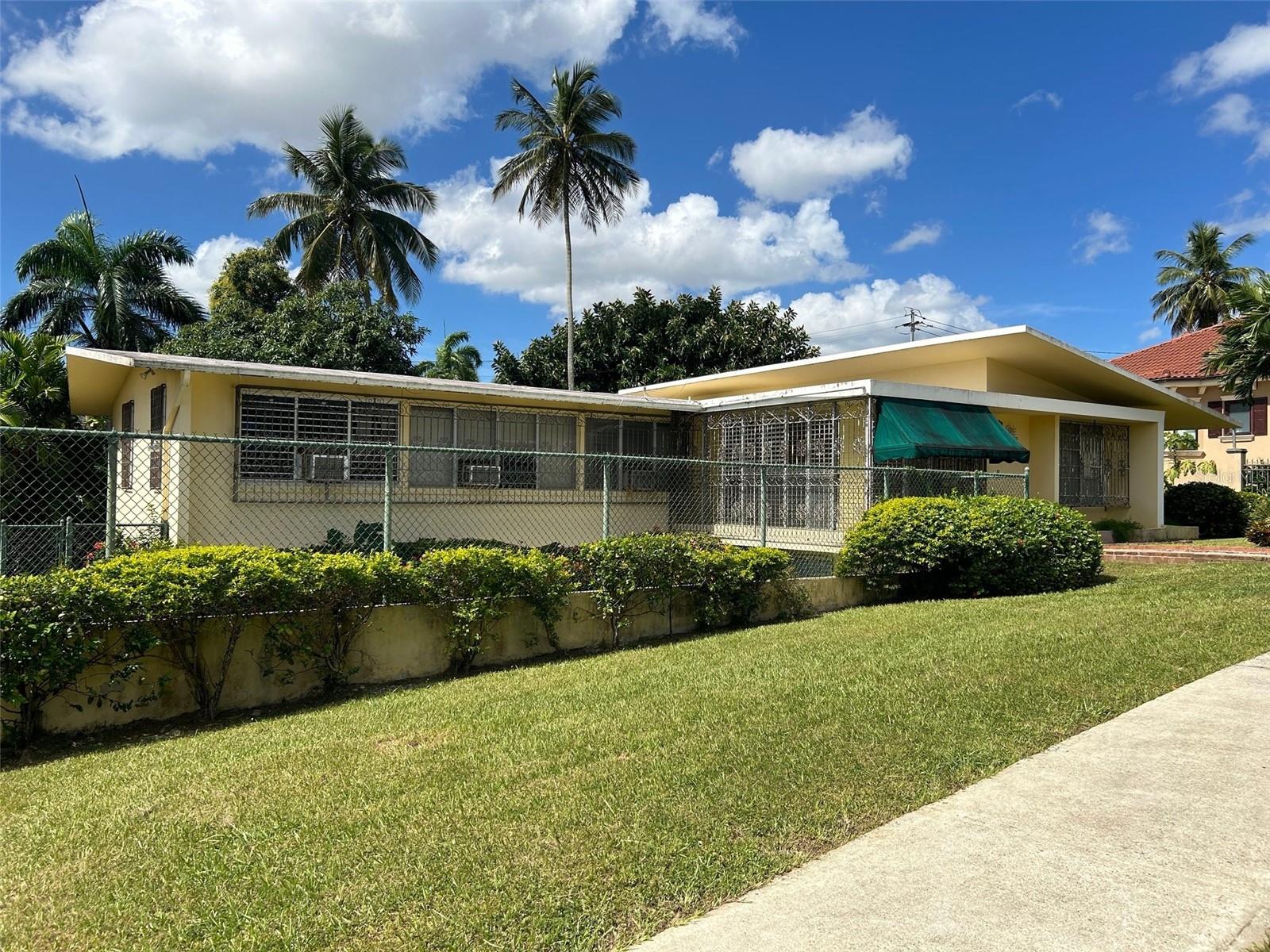 Located within the gated community of Garden Hills Norte in Guaynabo, Puerto Rico, this spacious residence offers a unique opportunity for large-lot living with premium redevelopment potential. The home features approximately 3,118 sq. ft. of interior space set on an oversized 928.68 m² lot, providing abundant room for custom upgrades and outdoor living.
The current configuration includes four bedrooms and four bathrooms, a two-car carport and extended driveway, plus patio and porch areas that invite a tropical indoor-outdoor lifestyle. With a strong foundation and solid construction, the residence presents an ideal blank canvas for transformation into a modern luxury designer home featuring an open concept floor plan, gourmet chef’s kitchen, resort-style pool and lounge deck.
Garden Hills Norte is highly sought after for its location, privacy, and quality of community living. Situated minutes from top schools, fine dining, upscale shopping and major highways, this property offers both a rare renovation prospect and long-term appreciation potential within premium Puerto Rico real estate and Guaynabo real estate.