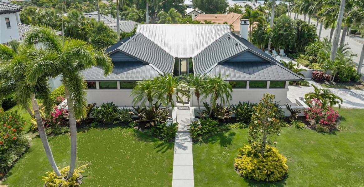 Discover timeless architectural elegance at Bird Key in this exceptional mid-century modern home. Originally designed by renowned Sarasota School of Architecture architect Tim Seibert, this extensively renovated home blends iconic design with modern luxury across more than 3,000 square feet of living space. 
Set on a lushly landscaped corner lot in one of Sarasota’s most prestigious communities, this abode features soaring ceilings, pecky cypress beams, Brazilian cherry hardwood floors, marble finishes, and expansive folding glass doors that create seamless indoor-outdoor living. The open-concept floor plan offers spacious living and entertaining areas, including a beautifully updated kitchen with solid wood cabinetry, marble countertops, premium appliances, and a cozy fireplace. 
The private courtyard and tranquil gardens, complete with a lovely swimming pool, provide a serene outdoor retreat, while the oversized primary suite serves as a private indoor retreat, complete with a walk-through closet and two separate his and hers bathrooms, offering the most exceptional comfort and functionality. An oversized guest ensuite provides luxurious accommodations for family and visitors alike.  Additional highlights include a two-car oversized garage with a gorgeous new glass enclosure, wraparound porch, outdoor grill area, new metal roof, new hurricane impact windows, new paver driveway and abundant natural light throughout. 
Located just minutes from downtown Sarasota, St. Armands Circle, marinas, beaches, and the Bird Key Yacht Club, residents enjoy the perfect combination of privacy, security, and convenience in a 24-hour guard-gated community. This is a rare opportunity to own a true architectural gem in the heart of Sarasota’s waterfront lifestyle.