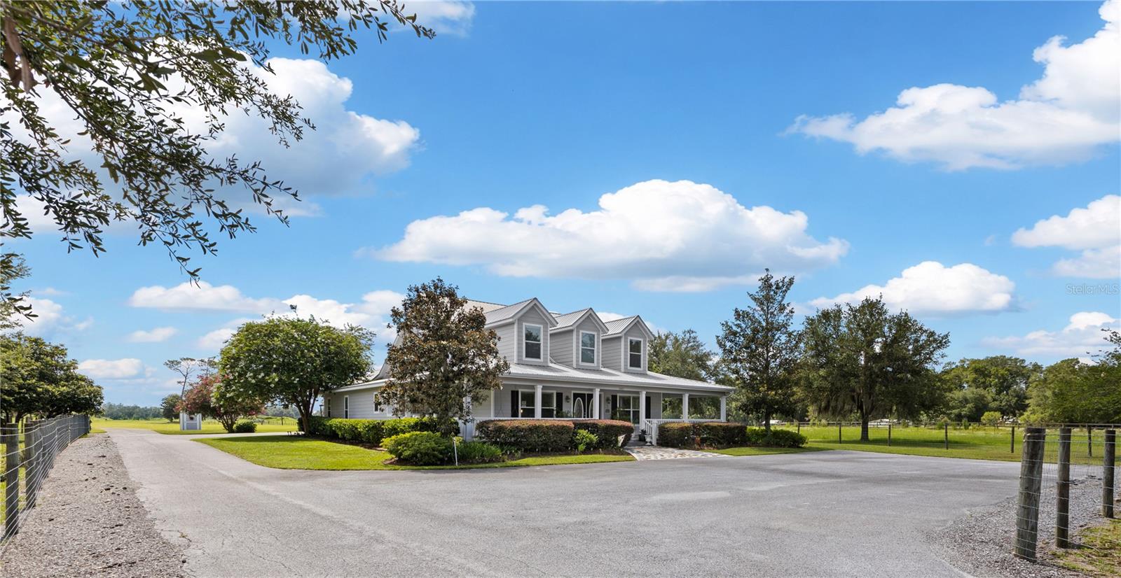 Some properties offer land. Others offer a lifestyle. This exceptional 27.7-acre farm in the heart of Marion County’s coveted horse country offers both.
Imagine beginning your mornings with coffee on the wraparound porch or relaxing in the spacious screened lanai as the sun rises over rolling green pastures, majestic oaks cast long shadows across the fields, and the only sounds are birdsong and the gentle rhythm of farm life. Ideally located in the heart of Florida's premier horse country, the property is just minutes from HITS, approximately 20 minutes from the World Equestrian Center, and a short drive to the renowned Goethe State Forest and Black Prong trail systems, offering miles of scenic riding, hiking, and outdoor recreation. This is the kind of address horse enthusiasts spend years searching for.
Beyond the gated entrance, a paved drive framed by mature oaks and lush pastures creates a classic farm-country arrival. Nestled within is a beautifully maintained farmhouse designed for gathering family and friends while embracing the outdoors that make this region so special.
The home offers over 3,300 square feet of thoughtfully designed living space, blending comfort with functionality. The open-concept kitchen, dining, and living areas flow seamlessly to the enclosed lanai and expansive covered outdoor entertaining spaces, creating the perfect setting for everything from quiet evenings at home to celebrations after a successful day in the show ring. Four generously sized bedrooms provide comfortable private retreats for family and visitors alike. Practically designed for both everyday living and farm functionality, the home offers an abundance of storage space including an oversized 35x26 garage. The wraparound porch and covered outdoor spaces invite you to slow down and enjoy the views from every direction
Beyond the home, the land tells its own story. Currently configured as a productive cattle farm, the property features pristine, improved pastures with running water, mature oaks, a stocked fishing pond complete with pier and platform, equipment sheds, workshop and an enormous six-bay pole barn. Yet what makes this property truly special is its versatility. Surrounded by some of the finest equestrian facilities in the country, the farm offers ample room to create the horse property you've always envisioned—whether that means a custom show barn, training arena, breeding operation, or private equestrian retreat.
While located in one of Florida's most sought-after equestrian corridors, this property's appeal extends far beyond horses. The rich pastures, mature oaks, and efficient layout offer endless possibilities for cattle, small livestock, hobby farming, gardening, or simply enjoying the privacy and freedom that come with nearly 28 pristine acres. Spend afternoons fishing from your private pond, watching wildlife wander through the shade of the oaks, or gathering family and friends under the pavilion. Blending the beauty of North Central Florida's countryside with convenient access to nearby amenities, this is where lasting memories are made and country living is enjoyed to the fullest.
In a region where location is everything, opportunities like this are increasingly rare. Whether your passion is horses, cattle, outdoor recreation, or simply enjoying the beauty and tranquility of North Central Florida's most desirable farm corridor, this remarkable property offers the space, setting, and lifestyle to make it a reality.