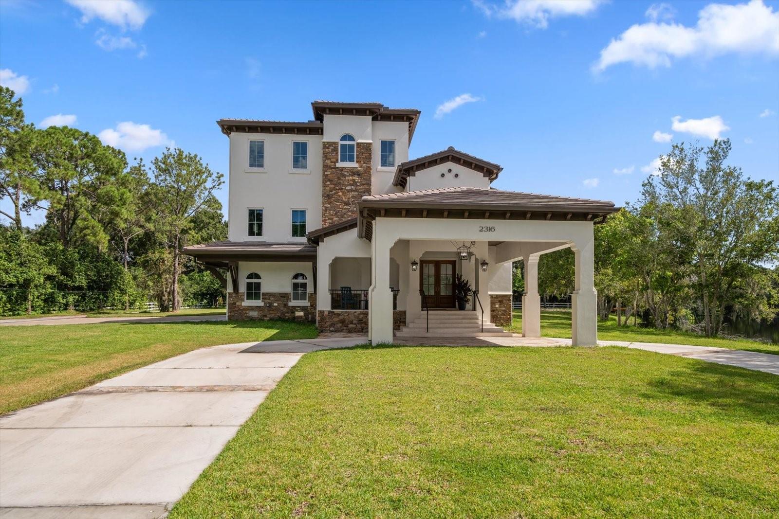 No flooding or damage from the recent storms and priced below recent appraisal! Experience this meticulously newly built modern luxury home that epitomizes elegance, comfort, and functionality on 2 acres with views of of your private pond. This three-level estate with opulence from every corner, seamlessly blending modern convenience with an architectural masterpiece design. Upon entering through the stately double doors, guests are greeted by a foyer adorned with travertine floors, iron staircase, custom wood ceilings, and floor to ceiling windows. The heart of the home unfolds into a spacious open living area framing the wonderful views of the lush surroundings, inviting in the natural light to fill the home. The gourmet kitchen, a culinary enthusiast's dream, features state-of-the-art appliances, Wolf gas cooktop & oven, Sub-Zero refrigerator, seamlessly integrated into custom cabinetry with gorgeous granite countertops. A sprawling island with a sink offers ample space for casual dining or entertaining. A gas fireplace with multi-colored flames can be seen in the family, kitchen, and formal dining areas for that perfect ambience. The nice size game room has lots of bar space complete with a sink and refrigerator to entertain all your guests. Just off the kitchen area is a bedroom with its own bathroom and walk-in closet. On this floor, you have a full sized laundry room that also has a refrigerator for extra food storage. Ascending to the upper level via a designer staircase that has lighting for each step or enjoy the private elevator, one discovers an array of generously proportioned bedrooms, each with its own en-suite bathroom. A highlight of this luxurious abode is its dual primary suites — an indulgent haven for both Him and Her. His Suite has a walk-in closet with custom built-ins, nice size bedroom, a bathroom with double sinks, and walk-in shower. Meanwhile, the Her Suite is pure serene elegance with its soft hues, custom walk-in closet, and spa like bathroom. Her bathroom has a soaking tub, double sinks with a makeup area and huge shower. A luxury home that epitomizes elegance, comfort, and functionality. 2 additional bedrooms with their own bathrooms, a loft area that would be a great study area or library, full size laundry room with a desk, and 2 storage closets complete the 3rd floor. Practical amenities abound throughout the residence, including a fully equipped five-car garage with dedicated electric vehicle charging stations, 600 Amp service and entire home is equipped with a robust generator capable of powering the entire estate during any unforeseen outages. For those envisioning a multi-generational household, there are plans for an in-law suite with it's own private entrance. This flexible space ensures comfort and independence for extended family members or guests. Have you heard of Lucas Lagoons? They have the hit show Insane Pools: Off the Deep End. You will see the design they have completed for an amazing pool! The custom design plans will convey with the home, they were $10,000 just for the design! Now you can own those plans and build your own incredible pool! In essence, this luxury home epitomizes the pinnacle of modern living, offering unparalleled craftsmanship and sophisticated design. From its expansive interiors to its serene outdoor spaces, this estate stands as a testament to luxury and elegance. This home is waiting for your finishing touches!