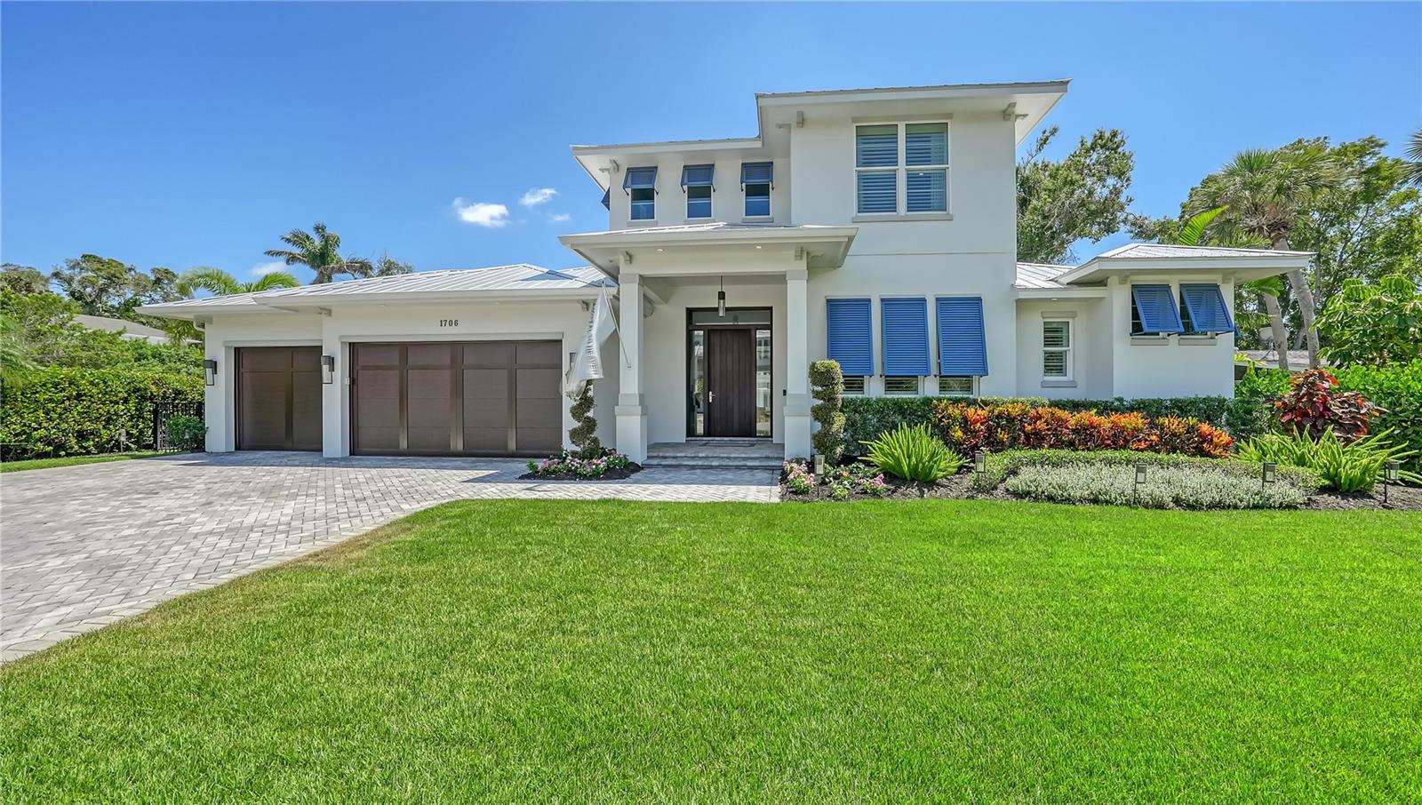 Immerse yourself in the epitome of coastal elegance with a contemporary flair. Exquisitely crafted by the renowned Najjar Construction and loaded with upgrades, this luminous sanctuary, 3 bedroom with an optional fourth, is embellished with 4 luxurious baths and a south-facing pool adorned with premium upgrades. Merely a stone's throw from the illustrious Cherokee Park, its coveted West of Trail location positions you just moments away from the enchanting Siesta Key Beach, the iconic St. Armands, and the vibrant heart of downtown Sarasota. Upon arrival, be captivated by a majestic Mahogany Entry that beckons prestige. Step into a soaring two-story foyer, where to your immediate right lies an intimate study, deliberately situated at the home's forefront to offer tranquility and focus. As you venture further, a strategically placed wine/dry bar enhances the home's architectural finesse. Elegantly unfolding is the fluid expanse of the living, dining, and kitchen areas, where quartz countertops lend a touch of modern sophistication to this coastal masterpiece. Whether you're hosting lavish soirées or seeking serene solitude, this layout effortlessly caters to every desire. Adjacently, a lavish bathroom offers direct pool access, while a discreetly placed laundry and mud-room seamlessly lead you to a spacious 3-car garage. The master suite, a realm of opulence, boasts dual bespoke closets. Luxuriate in the master bath's enhancements, from a standalone soaking tub and expansive walk-in shower to a vanity illuminated by under-mount lighting and crowned with exquisite stone countertops. Ascend the staircase to discover a versatile loft, poised for transformation into an additional bedroom. This home also includes Hurricane impact windows and doors, a full house generator, and a metal roof making this home a fortress and providing maximum protection against storms. Also features reverse osmosis on the entire home. Indulge in Florida's perennial bliss by the pool or savor moments by the spring-fed lake, basking near the fire pit and sizzling sumptuous steaks in the gourmet summer kitchen. Here in Sarasota, your dream of unparalleled luxury awaits.