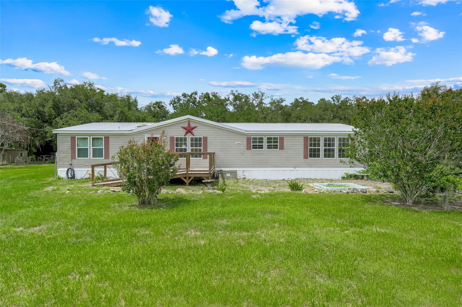 Rare opportunity to own a fully fenced 5-acre agricultural property featuring TWO permitted residences, a screened pool, a 2,400 SF barn, detached garage, multiple outbuildings, and endless possibilities for multi-generational living, homesteading, farming, agricultural use, or income-producing opportunities.

The primary residence offers 3 bedrooms, 2 bathrooms, and approximately 1,984 square feet of living space. The second residence, built in 2023 and featuring its own mailing address, offers 2 bedrooms, 2 bathrooms, approximately 1,334 square feet of living area, a finished carport, and a spacious covered porch.

Outdoor amenities include a screened swimming pool with an oversized pool deck and enclosure, providing the perfect setting for entertaining and enjoying Florida's year-round sunshine. The fully fenced acreage offers ample space for livestock, horses, equipment, RVs, gardening, and recreational activities.

The impressive 2,400 SF pole barn, built in 2023, provides excellent space for agricultural operations, equipment storage, livestock, workshops, or hobby use. 

With over 3,300 square feet of combined living space, agricultural zoning, and extensive infrastructure already in place, this property offers exceptional flexibility and value. Seller is offering up to $25,000 in concessions toward repairs or improvements to the primary residence with a full price offer.

Enjoy the privacy and open space of this agricultural property while remaining conveniently located near Groveland, Clermont, shopping, dining, and major roadways. Properties offering two permitted homes, agricultural zoning, a pool, barn, and five fenced acres are exceptionally rare. Schedule your private showing today!
