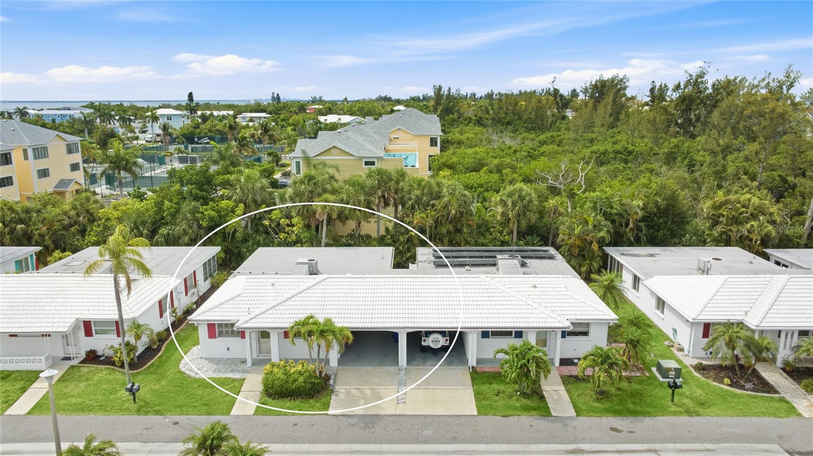 Welcome to Spanish Main Yacht Club, one of Longboat Key's most beloved waterfront communities, where 55-plus living unfolds at an easy, unhurried pace between the Gulf of Mexico and Sarasota Bay. Tucked along a quiet street lined with tidy single-story villas and swaying palms, this fully renovated two-bedroom retreat captures the old-Florida charm that makes this island enclave so special, paired with the fresh, move-in-ready updates. Behind the arched front entry and crisp white stucco exterior with its white tile roof, a bright open interior welcomes you, where neutral tile floors run throughout and natural light pours through plantation-shuttered windows. The renovated kitchen is the heart of the home, outfitted with white shaker cabinetry, quartz countertops, a waterfall-edged peninsula, a soft glass-tile backsplash, and crisp white appliances, all opening to a generous living and dining area finished with crown molding and an easy coastal feel. A versatile bonus room wrapped in windows, with a door to the back patio, makes a wonderful sunroom, reading retreat, or home office. Both bedrooms are comfortable and well-appointed, served by two beautifully updated bathrooms, one with a tub and shower framed in subway tile, the other a glass walk-in shower with a mosaic floor and designer fixtures. A covered carport with room for a golf cart, plus interior storage for kayaks and beach gear, adds everyday ease. Brick paver walkways and lush tropical landscaping wrap the home, and the concrete tile roof is just over five years young. Life at Spanish Main is built around the water and the warmth of neighbors. Residents enjoy a heated pool overlooking the basin, a clubhouse, shuffleboard courts, kayak storage and launch, and a deep-water marina with boat slips available for a monthly fee, offering quick access to Sarasota Bay and the Gulf beyond. Best of all is the community's private Gulf beach access, just a short stroll away, along with shaded benches lining the lagoon and a waterfront green where slow mornings and golden evenings by the water become a way of life. Beyond the community, the white sand of Longboat Key's Gulf beaches is moments away, with the boutiques and dining of St. Armands Circle, downtown Sarasota's culture, and the laid-back charm of Anna Maria Island all within easy reach. Come experience the rare blend of comfort, community, and coastal beauty that makes this villa a place to call home. **THIS PROPERTY QUALIFIES FOR A 1% LENDER INCENTIVE IF USING PREFERRED LENDER. INQUIRE FOR MORE DETAILS.**