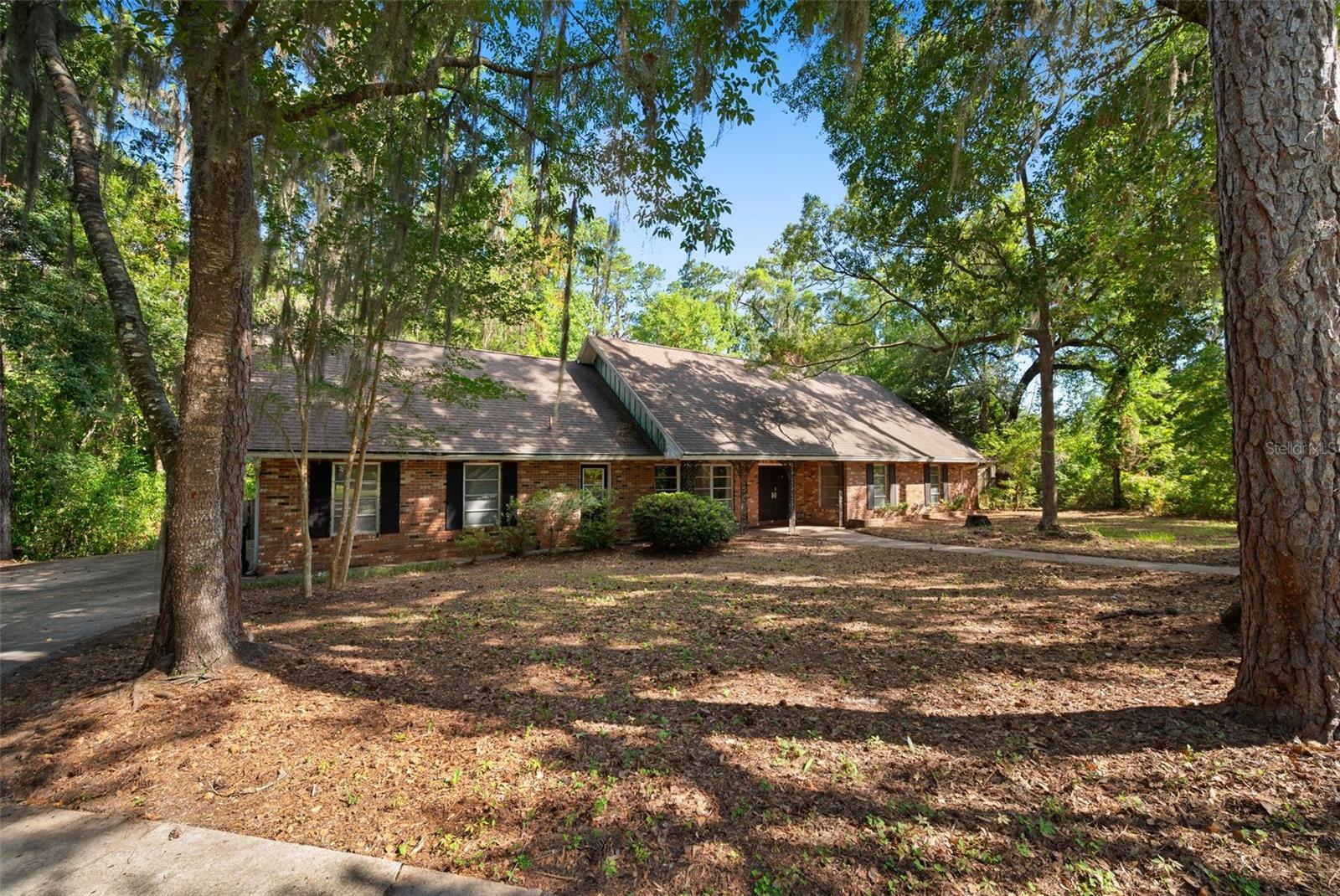 Are you ready to renovate?? Nestled on a quiet cul-de-sac in desirable Brywood, this spacious two-story pool home is waiting for its next chapter. Situated on an impressive 0.59-acre lot with an additional 0.76-acre parcel behind the home, the property offers exceptional privacy and endless possibilities. This 5-bedroom, 3.5-bath home has been owned by just two families and is ready for new owners to bring their vision and updates to the interior. Throughout the home, you'll find distinctive mid-century modern architectural elements that set it apart. A dramatic open staircase serves as the home's striking focal point, showcasing clean geometric lines and open risers that create an airy, light-filled atmosphere. The floor-to-ceiling stone fireplace, with its minimalist design and bold vertical presence, anchors the living space, while the sunken living room provides a warm, inviting setting for gathering and entertaining. The thoughtful floor plan includes two downstairs bedrooms connected by a Jack-and-Jill bathroom, along with a convenient half bath. Upstairs, you'll find two additional bedrooms sharing a Jack-and-Jill bath, as well as the spacious primary suite featuring its own private ensuite bathroom. Step outside to enjoy the screened porch overlooking the pool, where you can relax in the peaceful surroundings and appreciate the privacy this unique property provides. Major updates include: Roof (2012) Re-plumbed (2020) Water heater (2020) Pool resurfaced within the last few years. With great bones, timeless architectural character, and an extraordinary homesite, this is a rare opportunity to create your dream home in one of Brywood's most desirable locations. Bring your ideas and make it your own! Some photos have been virtually edited to remove items.