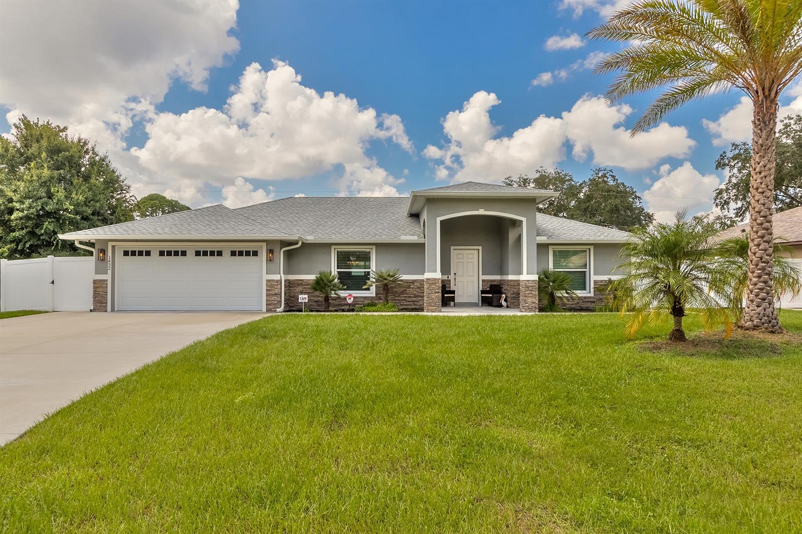This perfect beach style home is better than new! This beautiful 3 bedroom, 2 bathroom with 2 car garage home was custom built just last year in 2021. Upon walking through the front door you will notice the flawless presentation of the high cathedral ceilings, down to the luxury vinyl plank flooring with tall baseboards throughout. The open floor plan has the perfect layout for entertaining guests or hosting family gatherings. The kitchen is large and convenient, giving you plenty of cabinet and counter space. It contains stainless steel appliances, soft close cabinets, and granite countertops. Both bathrooms flaunt custom tile enclosures with granite counters. All of the fixtures throughout the home are top-notch. There is no need for hurricane shutters, as the windows are all hurricane wind rated. On the exterior of the home you'll love the delightful landscaping with perfectly placed palms. The front exterior walls show off custom stone work. The extended oversized driveway gives you plenty of parking, and the sidewalk goes around the entire house. The huge backyard has an open patio and a beautiful white vinyl privacy fence around the perimeter, making it the ideal spot for having BBQ's while watching your pets or kids play. This newly built home is low maintenance, comes with a warranty for the buyer, and is not in an HOA. It truly is the perfect home for the full time family or snowbirds alike. The location of this home is convenient to schools, entertainment, and hospitals. It's also less than a 15 minute drive to the Beautiful New Smyrna Beach. Make an appointment to take a look at this home today! ;Water: City