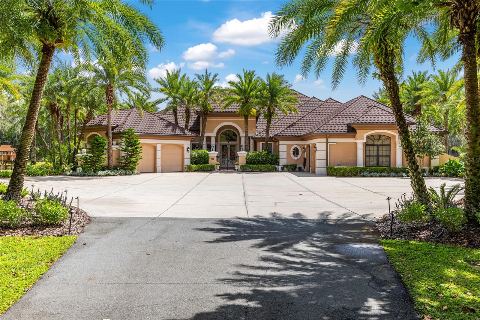 Experience luxury living on 17.5 acres in one of Ocala’s most desirable areas. This estate offers the privacy and serenity of a gated community setting without the added HOA costs or restrictions. While located within Bellechase, this property stands independently from the HOA — giving you freedom and flexibility.
Recently renovated and topped with a brand-new roof, as well as new closet systems throughout.  This 4-bedroom, 5-bathroom residence (plus office) blends modern updates with timeless elegance. Inside, soaring ceilings, a split-bedroom floor plan, and spacious gathering areas set the stage for both comfort and entertaining. The chef’s kitchen features high-end finishes and opens to a coffee/wine bar, while the master suite includes its own private office in addition to the home’s main office.
Step outside to enjoy the resort-style pool and spa, surrounded by lush landscaping, palm trees, and a variety of fruit trees. The property also includes a fully stocked pond for fishing, making it a true retreat. With A1 zoning, it’s perfect for a large family, animals, or anyone seeking a lifestyle that combines luxury and land.