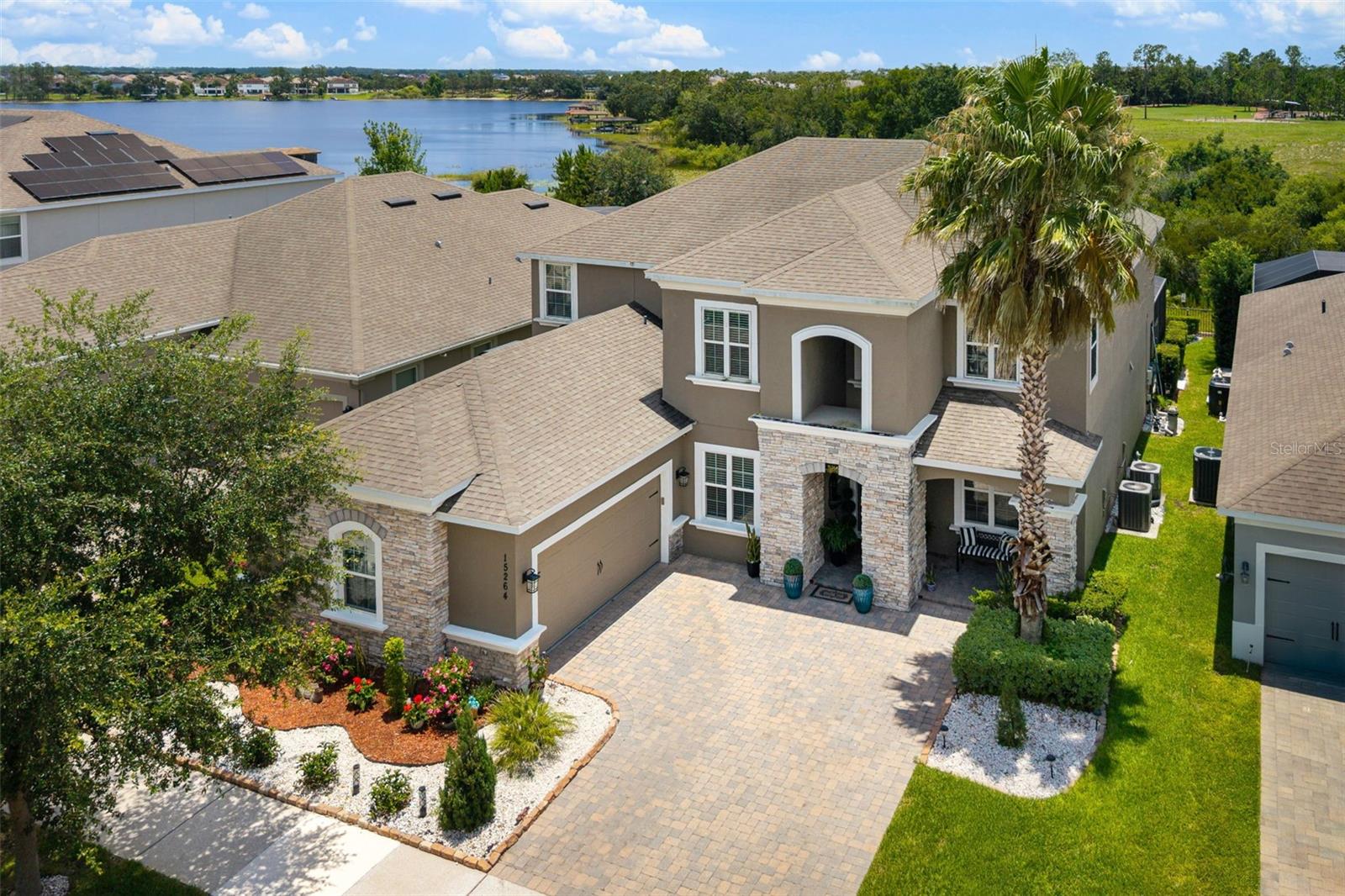 Welcome to this spacious 4-bedroom, 3.5-bath pool home offering 4,000 square feet in the highly sought-after Overlook at Hamlin community in Horizon West. Showcasing Lake Hancock views throughout the home and Disney fireworks in the distance, this property combines generous living space, impressive architecture, and an unbeatable location in one of Winter Garden's most desirable communities. From the moment you arrive, you'll appreciate the paver driveway, fresh landscaping, side-entry two-car garage, and curb appeal. Step inside to find a formal dining room and home office. Continue into the heart of the home where soaring ceilings and a dramatic two-story design create a bright, open atmosphere. The expansive family room showcases picturesque pool and lake views, while the open-concept layout flows seamlessly into the kitchen and casual dining area, making it ideal for everyday living and entertaining. The kitchen features granite countertops, light cabinetry, two oversized islands, abundant prep space, a walk-in pantry, and a butler's pantry ideal for a coffee station. Stainless steel appliances include a Monogram built-in oven and microwave, Monogram dishwasher, and a Monogram five-burner natural gas cooktop. The first-floor primary suite offers a private retreat with pool views, two walk-in closets, and an ensuite bath complete with dual vanities, a garden tub, and a large glass-enclosed shower. An impressive staircase with decorative iron balusters leads to the second floor, where an open overlook adds to the home's spacious feel. Upstairs you'll find three additional bedrooms, all with walk-in closets, two full bathrooms, a large loft perfect for a media room or secondary living area, and a versatile flex room that can serve as a home gym, study, playroom, hobby room, or potential fifth bedroom. Combined with the dedicated first-floor office, these flexible spaces provide exceptional versatility for remote work, multi-generational living, or growing households. Two upstairs bedrooms enjoy Lake Hancock views. Step outside to the expansive screened lanai with space for outdoor dining, relaxing, and entertaining. The saltwater pool and Lake Hancock views create an exceptional outdoor setting. Residents of Overlook at Hamlin enjoy access to a clubhouse, fitness center, resort-style pool, playgrounds, golf cart-friendly streets, and community lake access. Located just minutes from Hamlin Town Center, you'll enjoy convenient access to shopping, dining, waterfront restaurants, grocery stores, PopStroke, Cinépolis Luxury Cinemas, Urban Air, and everyday conveniences. A rare opportunity to own a spacious pool home with Lake Hancock views in the heart of Horizon West and Winter Garden's thriving Hamlin area.