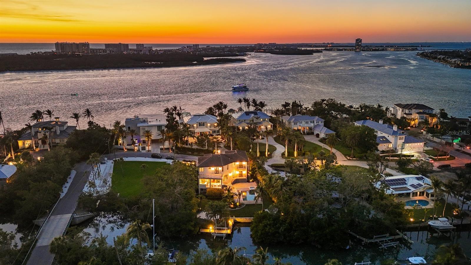 One or more photo(s) has been virtually staged. *Located on the north end of Siesta Key, this custom-built luxury waterfront home sits on a very private lot, surrounded by lush tropical landscaping and mature coconut palms. Perfectly positioned on a coastal playground just off Big Pass, it offers deep-water access, boating convenience, and serene natural beauty.
The flexible layout includes 5 en-suite bedrooms, an elevator to all three levels, and a spacious main-level suite ideal for guests or multigenerational living. An engineer-approved option to remove a non-load-bearing wall allows for easy creation of a great room concept—a virtual rendering is included in the photo gallery to illustrate the potential.
The chef’s kitchen features GE Monogram and Fisher & Paykel appliances, a butler’s pantry, beverage station, and pocketing glass doors opening to a full summer kitchen, PebbleTec saltwater pool and spa, and lush outdoor spaces.
Hurricane-rated windows and doors, elevated construction, and a full-home generator protected the interior during recent storms—no water intrusion or damage occurred, with water reaching only the garage level.
Extras include a 13,000 lb. lift, composite dock, 3-car garage with EV charger, whole-house water filtration, security system, and ample storage. A rare opportunity to own a private, resilient, and reimagined Siesta Key waterfront retreat.