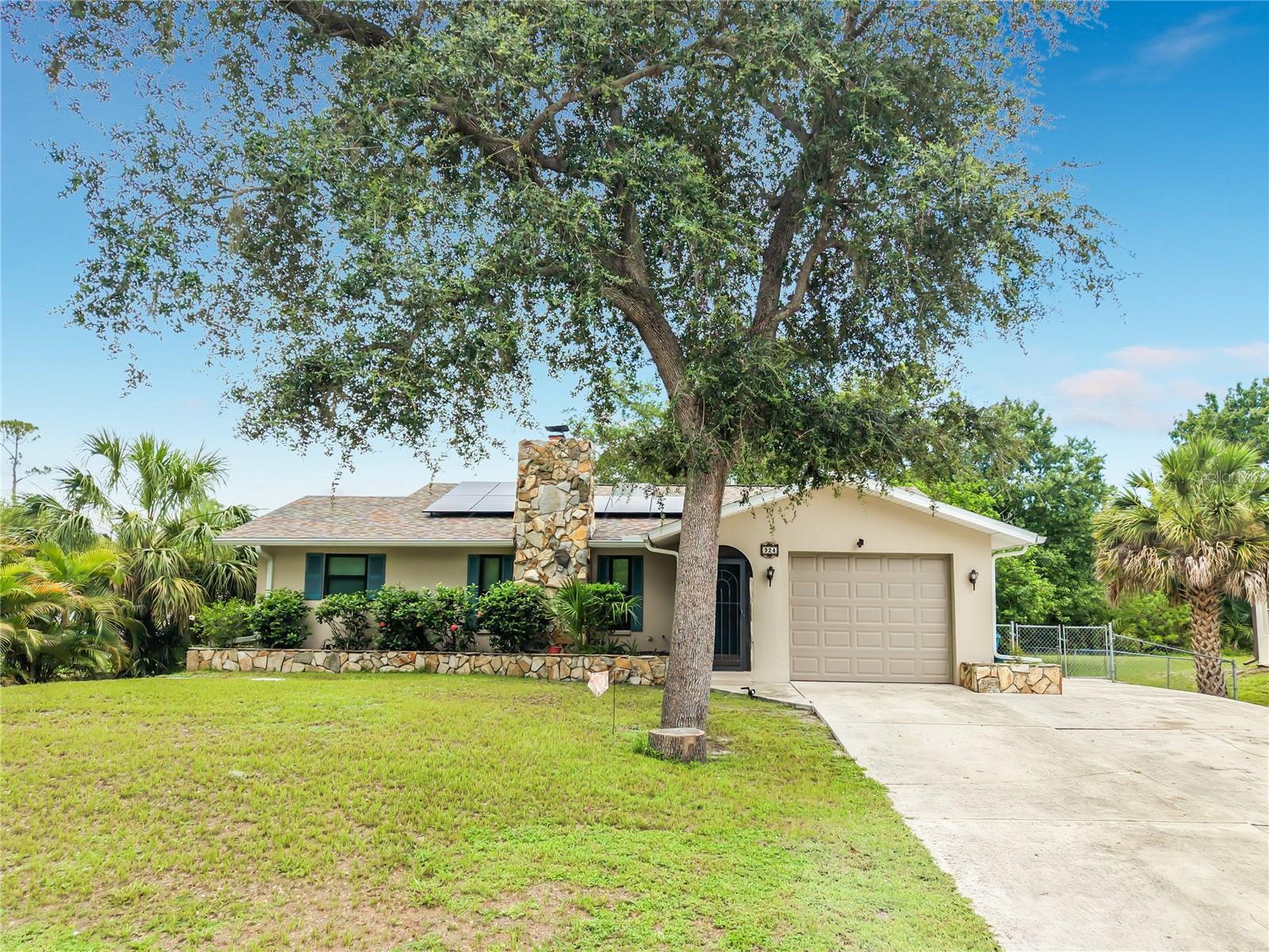 Welcome home to this charming, beautifully updated, furnished 2-bedroom, 2-bath residence offering comfort, character, and plenty of extra living space. Featuring a recently replaced septic system, leased solar panels, and numerous updates throughout, this move-in-ready home is perfect as a full-time residence, winter retreat, or investment opportunity.Step inside to find attractive tile flooring throughout, a new front entry door, and an inviting split-bedroom floor plan designed for privacy. The spacious great room showcases a stunning floor-to-ceiling stone fireplace, creating a warm focal point for family gatherings and holiday celebrations.The bright and cheerful kitchen features granite countertops, newer appliances, and a convenient pass-through window to the expansive 10' x 21' air-conditioned, screened sunroom. This enclosed bonus room provides valuable additional living space for entertaining, relaxing, or enjoying your morning coffee and is not included in the square footage reflected on the tax records.French doors from both the dining area and the primary bedroom open to the sunroom, creating seamless indoor-outdoor living and filling the home with natural light. The primary suite features an updated bathroom with a stylish new vanity and walk-in shower. Most of the home's windows have been upgraded to impact-resistant windows for added storm protection, energy efficiency, and peace of mind.The guest bedroom and bath are privately located on the opposite side of the home, making family and guests feel right at home. A separate inside laundry room with washer and dryer leads to the attached garage for added convenience.Outside, you'll appreciate the extra-wide driveway with ample parking, striking stone chimney, matching stone mailbox, raised stone flower beds, and screened front entry that enhance the home's unique curb appeal. The spacious backyard offers plenty of room to add a pool, and with no deed restrictions, you'll have space to park your boat, RV, or other recreational toys.Being offered furnished, this home allows you to move right in and immediately begin enjoying the Southwest Florida lifestyle. Conveniently located near beautiful Gulf beaches, boating, fishing, golf courses, parks, bike trails, shopping, restaurants, movie theaters, and boat ramps, this home truly has it all.Schedule your private showing.