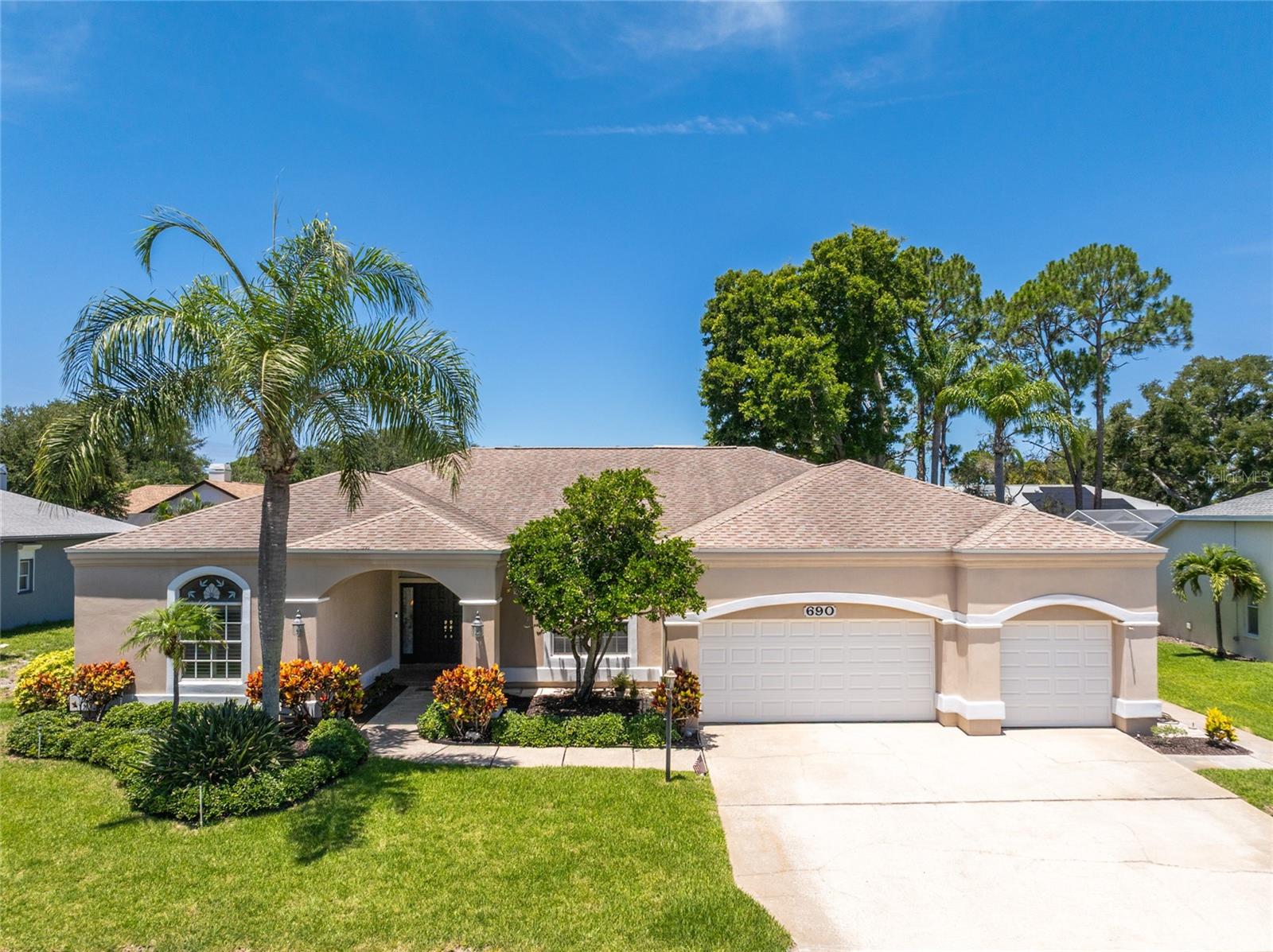 Take advantage of this rare opportunity to own a home in Dunedin's desirable Weathersfield community! This 4 bedroom, 3 bath, 3-car garage, POOL home with SPLIT FLOOR PLAN is perfect for families, and/or those who work from home and love to entertain! As you approach the home, you'll be impressed by the meticulously maintained landscaping and as you step through the beautiful wood double doors, you’ll immediately notice this home's natural light and be greeted with a beautiful view of the covered/screened patio and pool.  The generous formal living room and separate dining area have stunning wood floors which is carried throughout much of the home, including the Primary Bedroom. The spacious Primary Suite has two walk-in closets and is separate from the main living space and other bedrooms. It's open view and access to the pool make it a peaceful retreat to begin and end each day. The ensuite bath has an updated vanity with dual sinks, a storage tower and recessed mirrored medicine cabinets above each sink.  It also features a handy niche, window seat with storage, garden soaking tub, walk in shower and private water closet. The large kitchen offers tons of storage and counter space as it overlooks the pool and opens up to the dinette area and family room with a wood burning fireplace. There’s barstool seating, allowing you to connect with family and guests while hosting.  Bedrooms 2 & 3 share the 2nd full bath and Bedroom 4 has the 3rd full bath, which  also opens to the pool, is just steps away.  Sliding glass doors make up most of the rear of this home, so you can enjoy beautiful pool views from almost every room! Once outside you’ll appreciate the large back yard, in addition to the screened pool lanai with covered space to give shade during the warm summer months.  The vast majority of the windows feature 3M Ultra Scotchshield window film which is glass shatter resistant and features forced entry delay, impact resistance (although not Miami-Dade standard).  Several recent updates such as A/C (2025), A/C ULTRAVIOLET LIGHT (2024), WATER HEATER (2026), POOL PUMP and CHLORINATOR (both less than a year old), and POOL CAGE PAINTED and RESCREENED (2024). The home offers peace of mind, NOT located in a flood zone, it's high and dry and experienced NO water intrusion from the storms in 2024.  The Weathersfield community is warm and inviting with established, mature trees and meticulously manicured lawns. Situated around Jerry Lake, this neighborhood is upscale and quaint, with just 109 custom-built homes. Great location, the community is about a 5-minute bike ride to several local restaurants, boutique shopping, breweries, marina and waterfront that downtown Dunedin has to offer. Not to mention, just a short drive to world-famous, Honeymoon Island and Clearwater Beach. Call today to schedule your private showing!