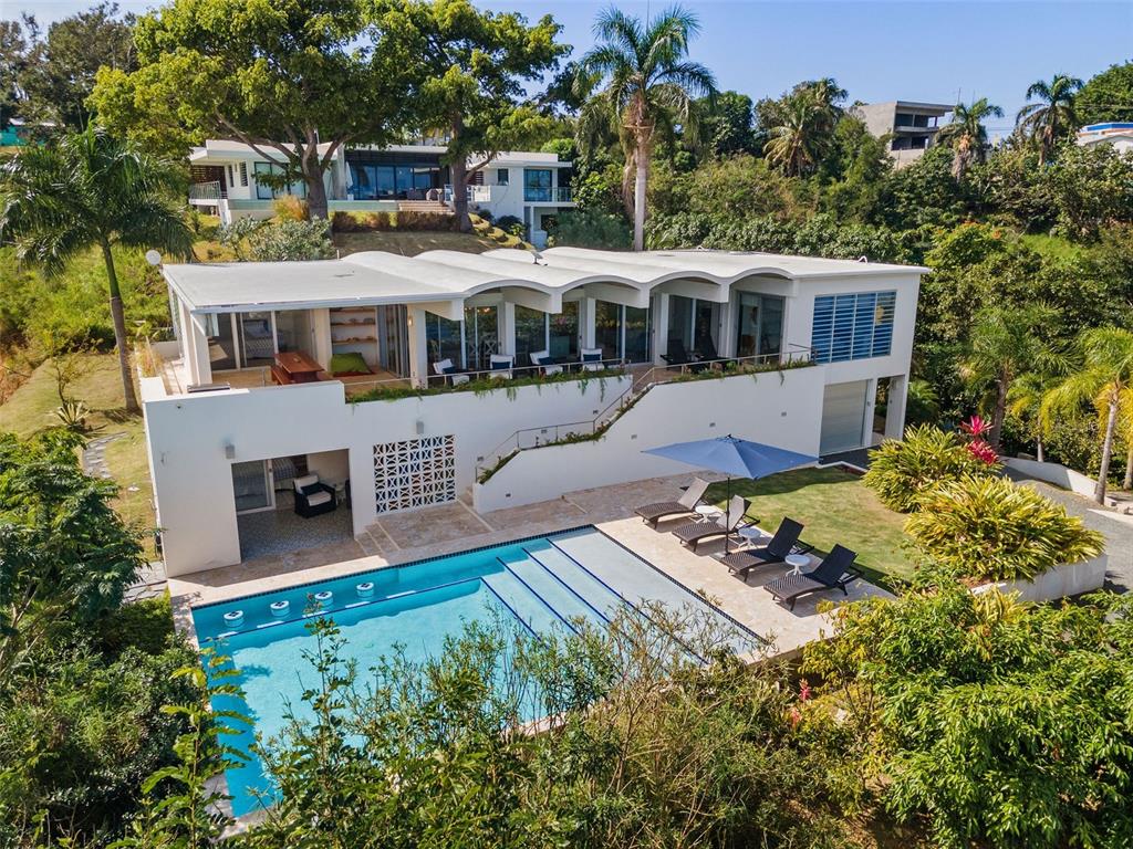 Contemporary Marvel with Sweeping Ocean Views – Designed by renowned New York architects Big Prototype, this magnificent single-family estate resides in Barrio Puntas - the most sought-after community in Rincon, known for spectacular ocean vistas and laidback elegance. This massive 6,300 square foot 5 bedroom, 4.5 bathroom home was designed to fully maximize it's premier hilltop location showcasing ocean views from nearly every room. From sunrise to sunset, the lush greenery, azure ocean, and fiery pinks of Rincon’s famed sunsets are your personal panoramic entertainment. Spread out over two floors, the barrel-vaulted ceiling brings a sense of amplitude and maximizes the open-plan living concept with an immense 30 ft x 40 ft great room. A surround sound system and a custom-built projection screen are hidden to allow for a movie theater quality experience, without sacrificing views or wall space. A separate TV area and offshoot of the living room provides even more space for lounging. Enjoy ocean views from the fully renovated kitchen featuring brand new LG appliances, an oversized island perfect to use as a breakfast bar and luxurious white quartz countertops throughout. The expansive terrace features a renovated outdoor kitchen and a large custom dining table providing multiple sizable spaces for entertaining Al Fresco. The main level has 3 bedrooms and 2 bathrooms off the principal living area, each with a sense of privacy and openness off the main terrace to appreciate the scenic views. On the second lower level, 2 bedrooms and 2 full bathrooms provide even more space and privacy. From the first level primary suite, an ensuite bathroom and private outdoor terrace provides the outmost peaceful retreat. Step out onto the charming colorful tile, inspired by 1960s spanish revival, and curl up with a book or dive directly into the oversized, heated saltwater infinity pool with swim-up bar. Celebrating its indoor-outdoor living concept, this palatial abode was meticulously designed as an entertainer’s dream. An outdoor shower and bathroom are thoughtfully placed off of the pool area. Large storage areas and a garage afford residents the ability to store every bit of gear needed to fully enjoy lounging at the beach and watersports. Relish the laid-back luxe ambiance that embodies the Rincon lifestyle - swimming, surfing, boating, hiking, fine dining, tranquility, nightlife, and the best sunsets in the Caribbean. 

The home includes an eco-friendly greywater collection system that optimizes water collection as well as a full cistern and generator offering its residents all the modern comforts expected in a home of this stature.  
 
Live or invest in the most exclusive sector of Rincon, located on the West Coast of Puerto Rico and known to be the surf capital of the Caribbean. A convenient 30 minute drive to the Aguadilla Rafael Hernandez Marin Airport, with direct daily flights from New York City, and other important city hubs make it an ideal destination in Puerto Rico. 

Get informed about Puerto Rico's Act 60 Tax Incentive Program. Let us help you call this beautiful island HOME. Learn More: https://www.taxincentivespuertoricoinfo.com/